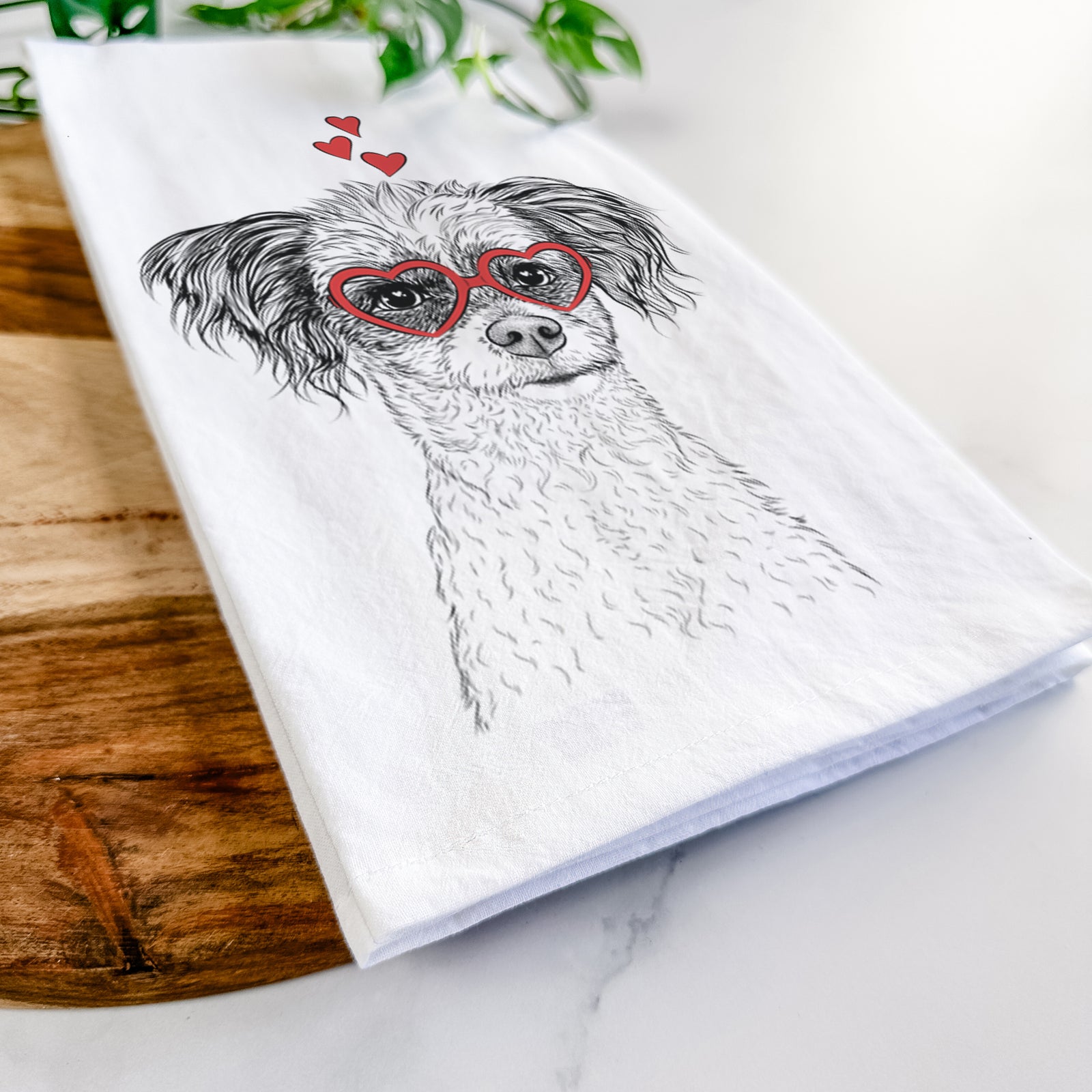 Hand-drawn sketch of Finley the Papillon Mix wearing heart-shaped glasses on a tea towel