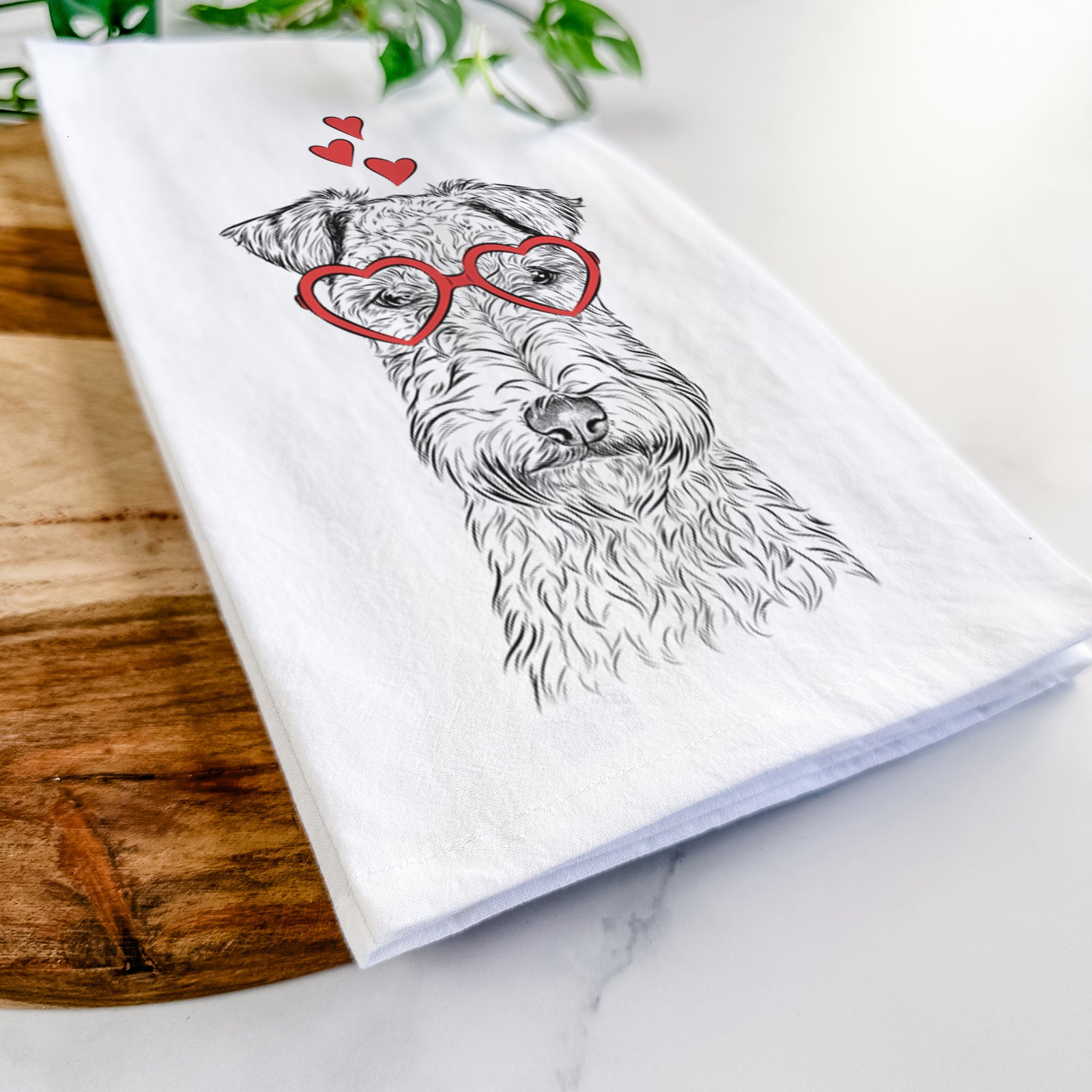 Hand-drawn sketch of Frida the Lakeland Terrier wearing heart-shaped glasses on a tea towel