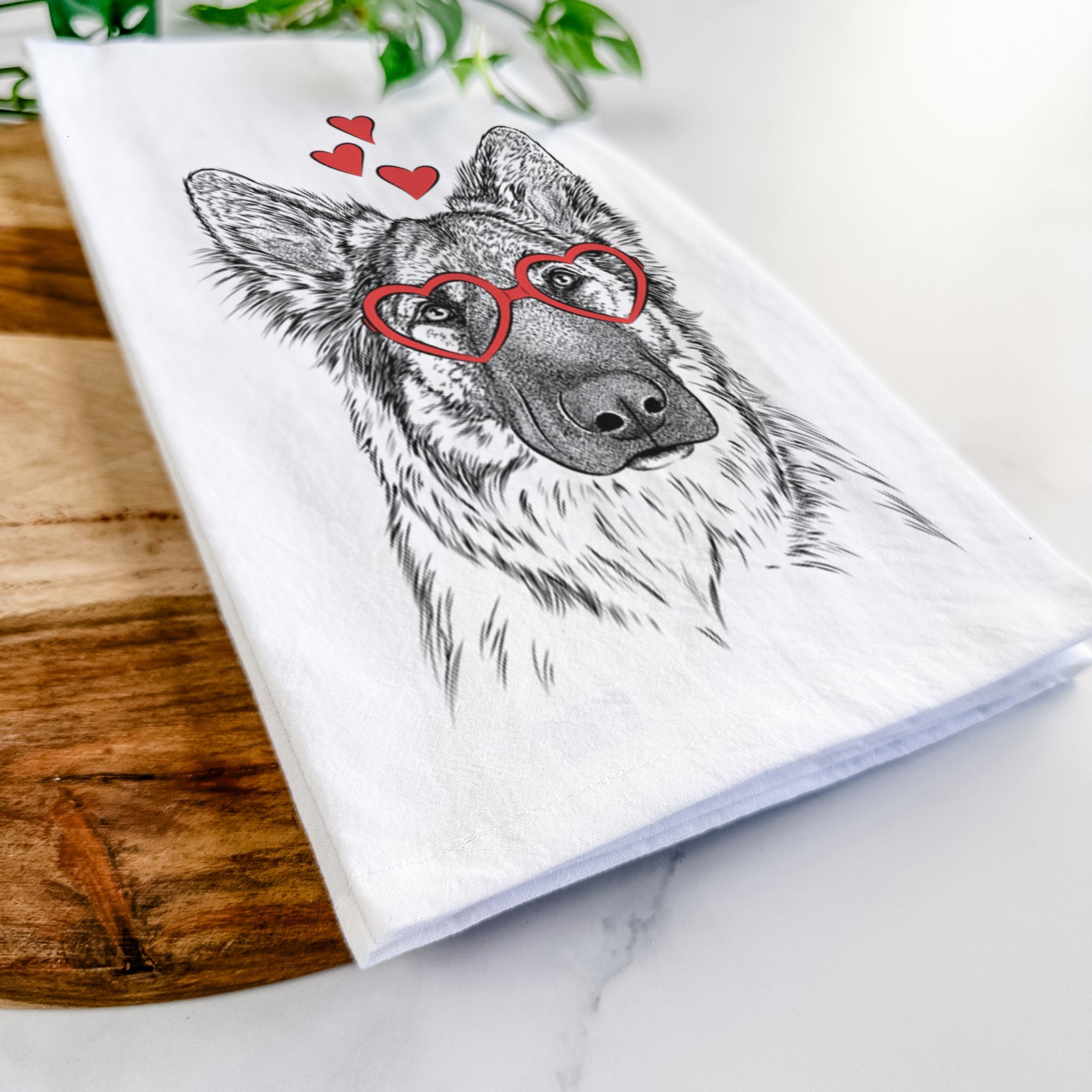 Hand-drawn sketch of Geddy the Shiloh Shepherd wearing heart-shaped glasses on a tea towel