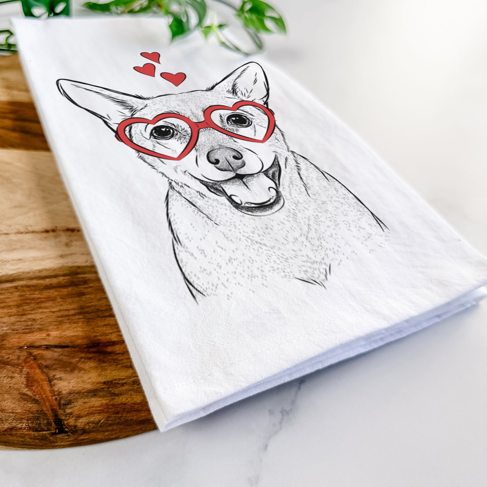 Hand-drawn sketch of Georgie the Chiweenie wearing heart-shaped glasses on a tea towel
