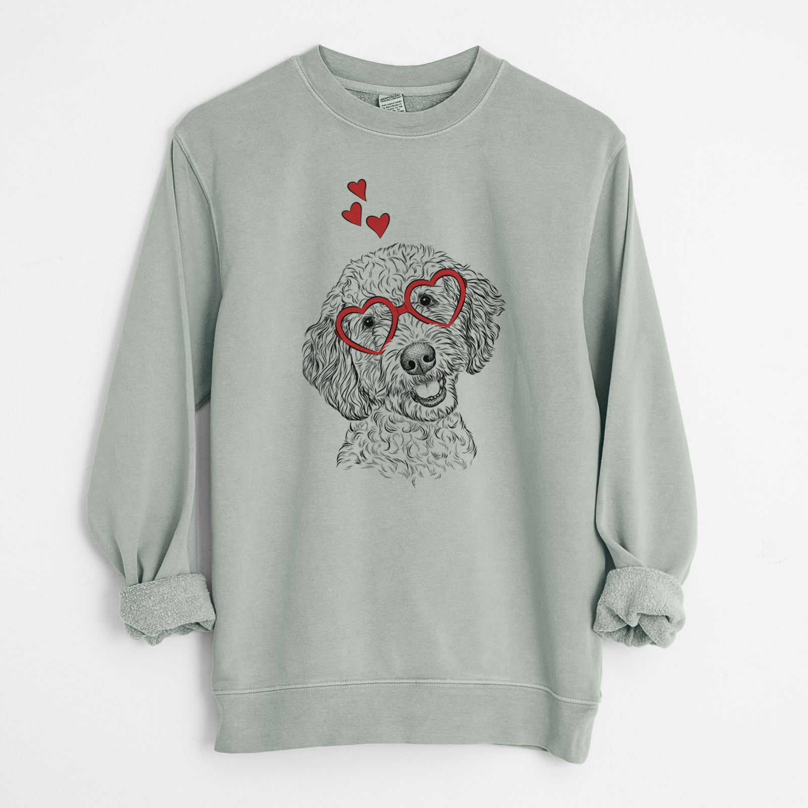 Hand-drawn sketch of Gizmo the Goldendoodle wearing heart-shaped glasses on a Sage Unisex pigment dyed crew sweatshirt
