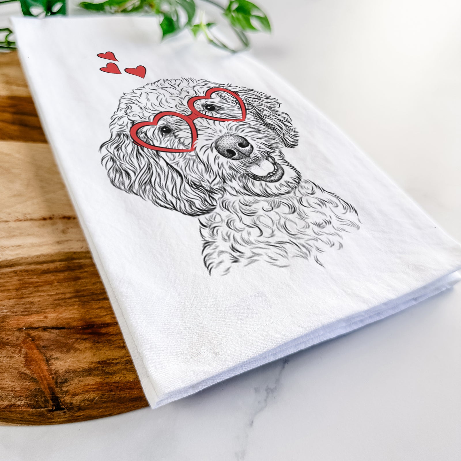 Hand-drawn sketch of Gizmo the Goldendoodle wearing heart-shaped glasses on a tea towel