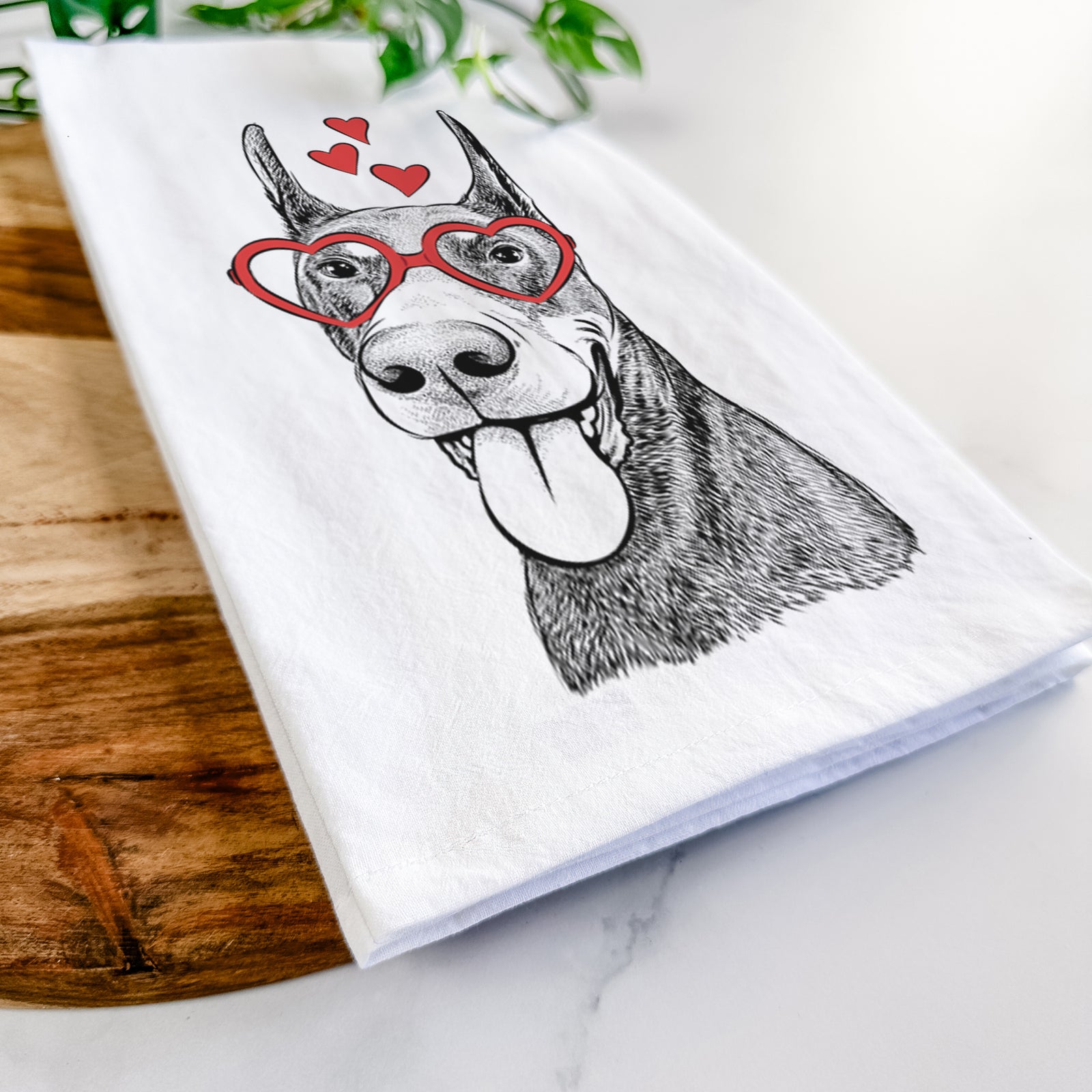 Hand-drawn sketch of Happy Sunny the Doberman Pinscher wearing heart-shaped glasses on a tea towel
