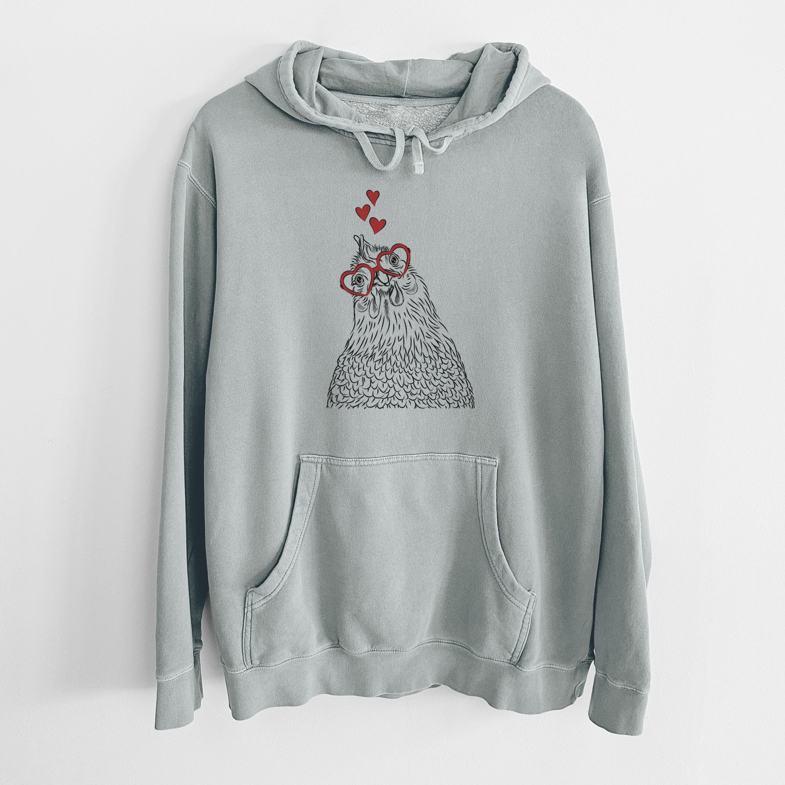 Hand-drawn sketch of Henrietta the Chicken wearing heart-shaped glasses on a Sage Unisex pigment dyed hoodie