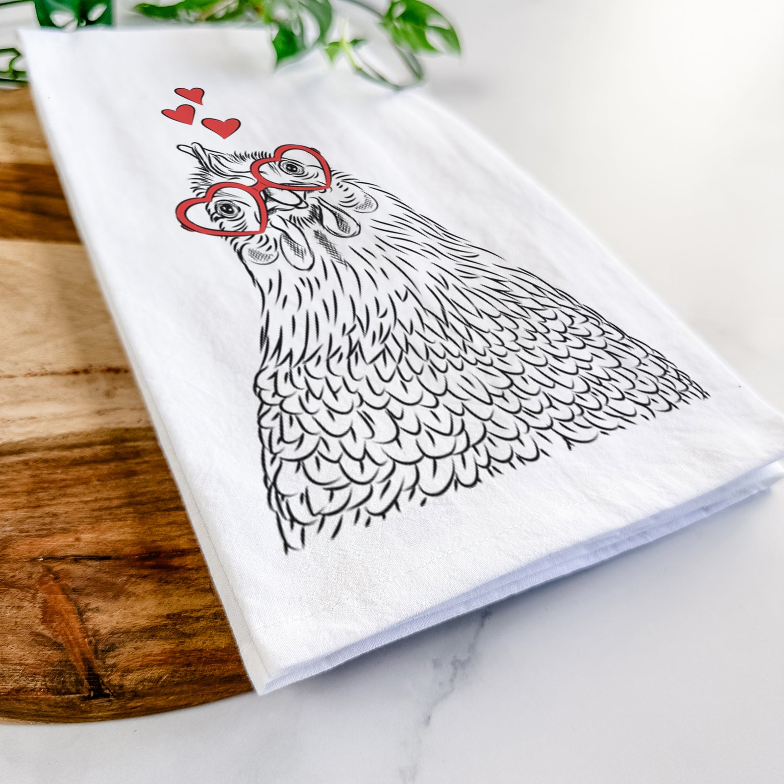 Hand-drawn sketch of Henrietta the Chicken wearing heart-shaped glasses on a tea towel
