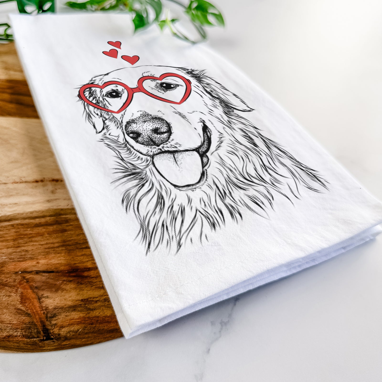 Hand-drawn sketch of Hopper the Golden Retriever wearing heart-shaped glasses on a tea towel
