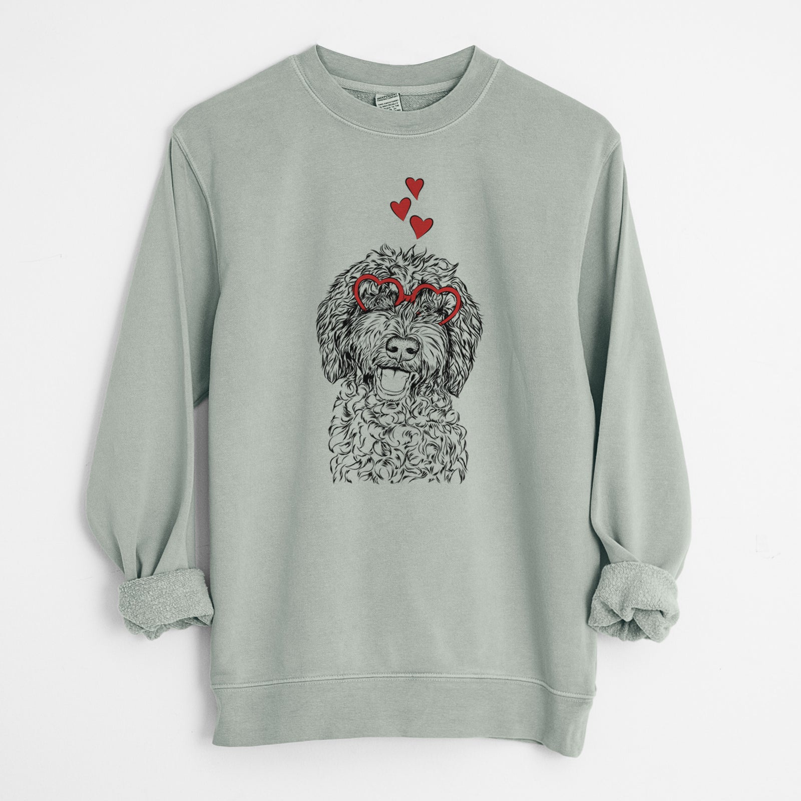 Hand-drawn sketch of Jack the Chocolate Labradoodle wearing heart-shaped glasses on a Sage Unisex pigment dyed crew sweatshirt