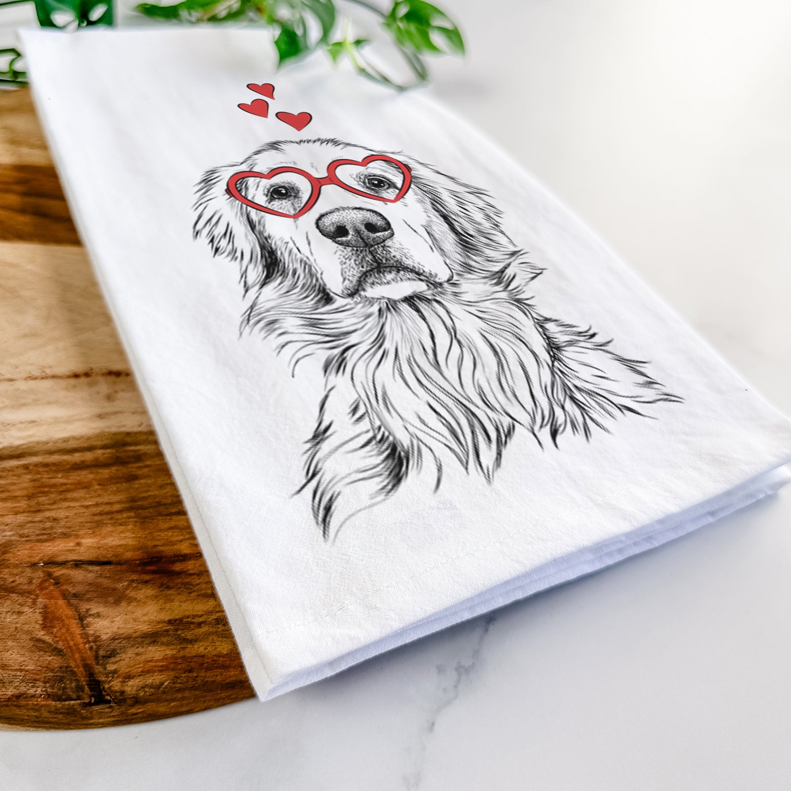 Hand-drawn sketch of Jake aroni the Golden Retriever wearing heart-shaped glasses on a tea towel