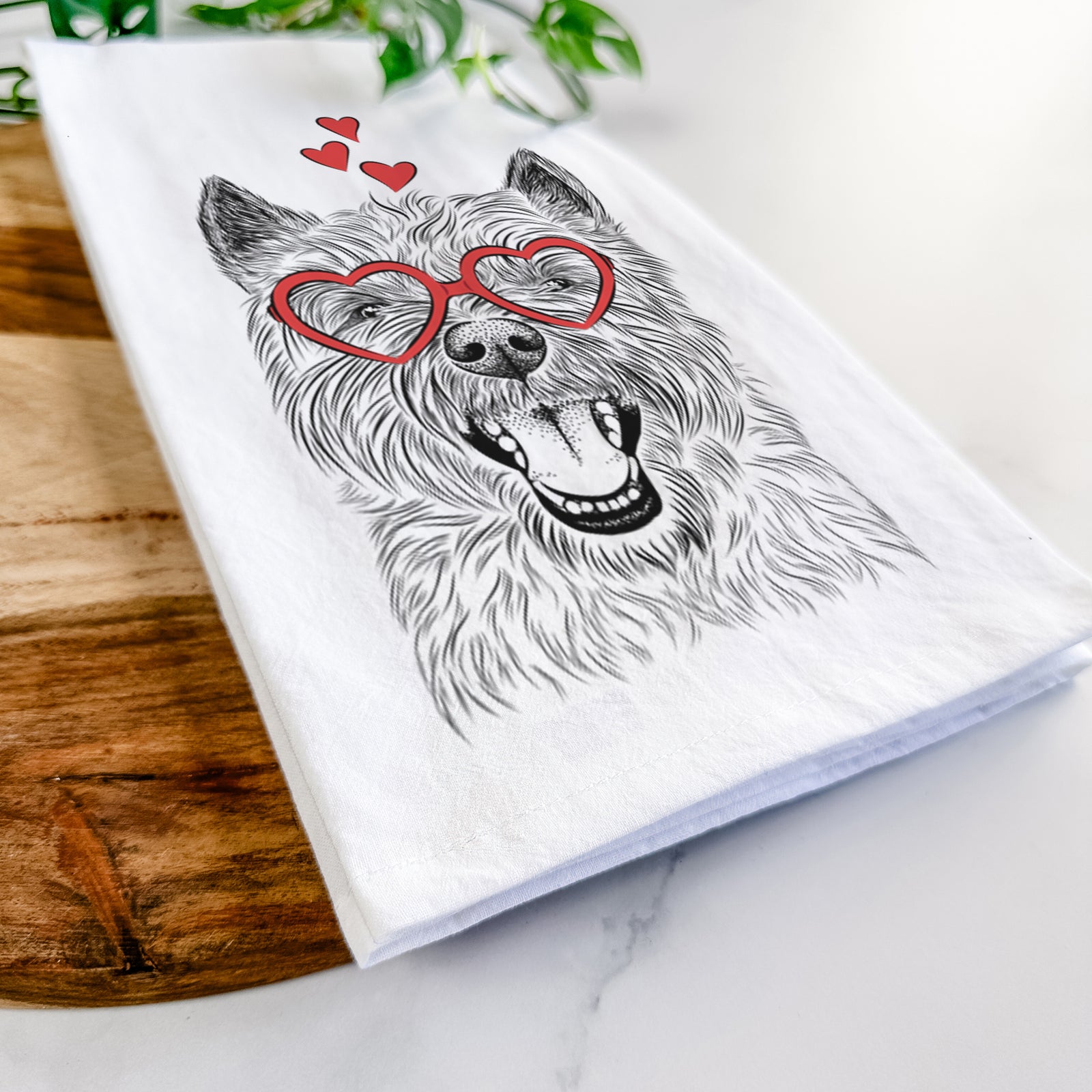 Hand-drawn sketch of Jeff the Cairn Terrier wearing heart-shaped glasses on a tea towel