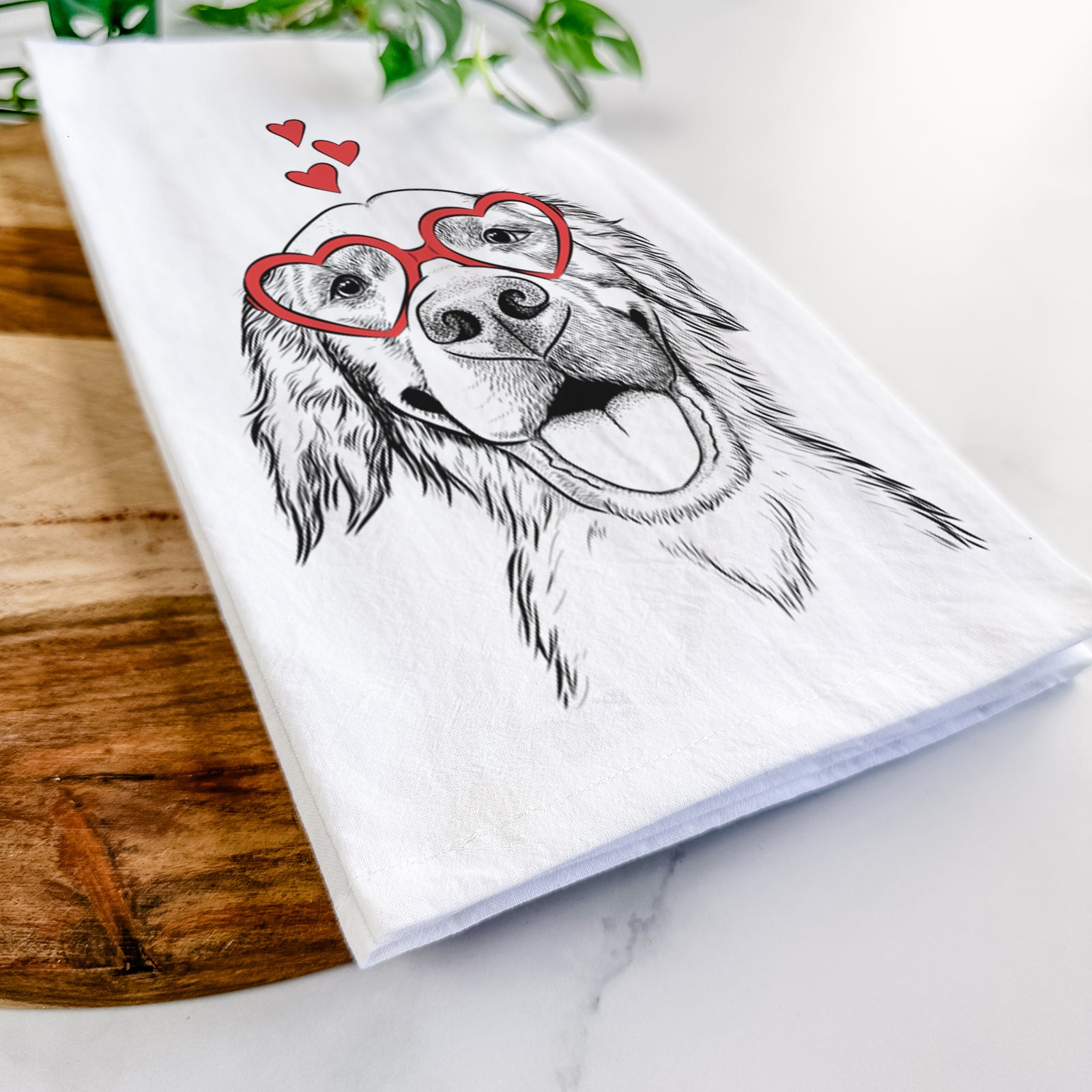 Hand-drawn sketch of Jordy the Golden Retriever wearing heart-shaped glasses on a tea towel
