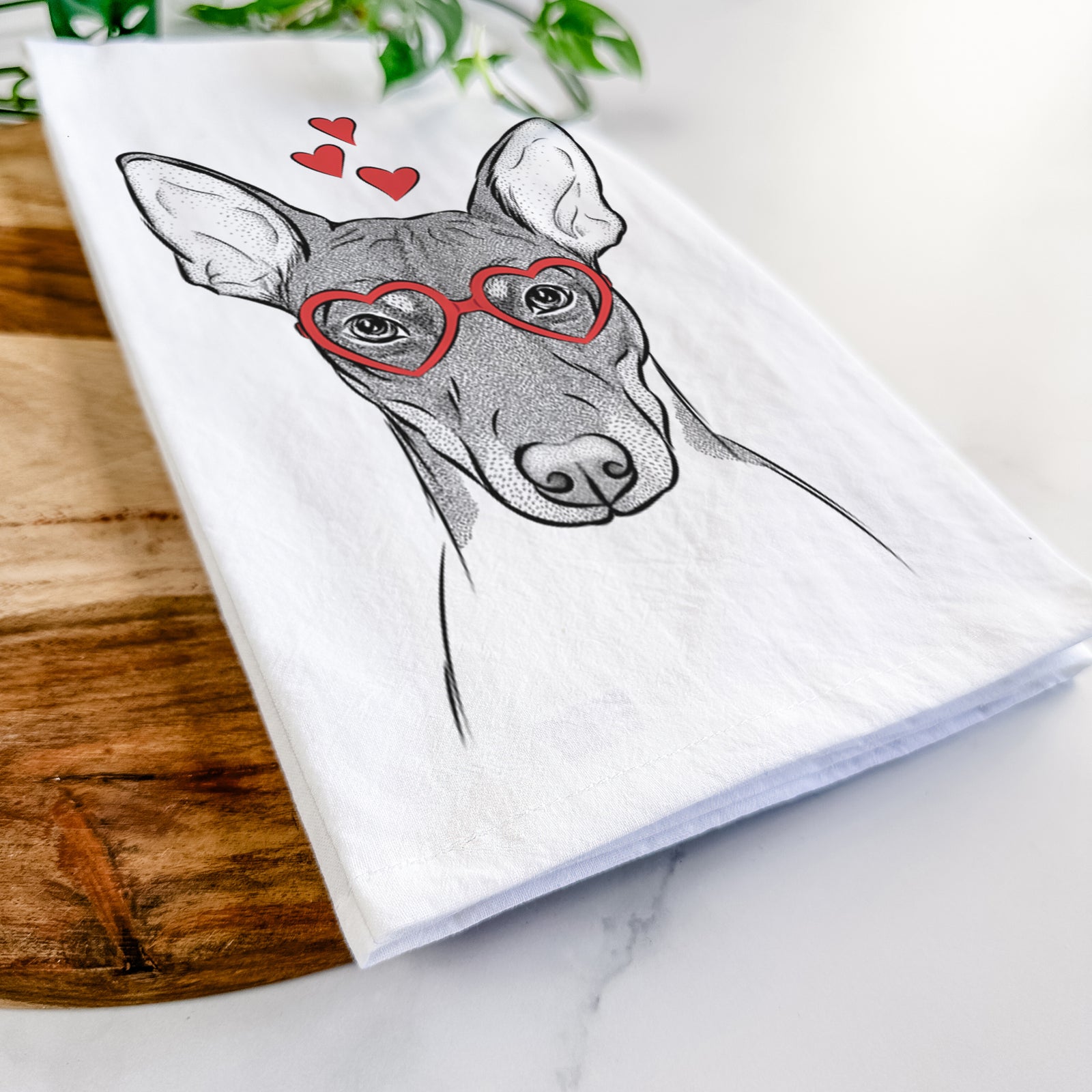 Hand-drawn sketch of Knox the Rat Terrier wearing heart-shaped glasses on a tea towel