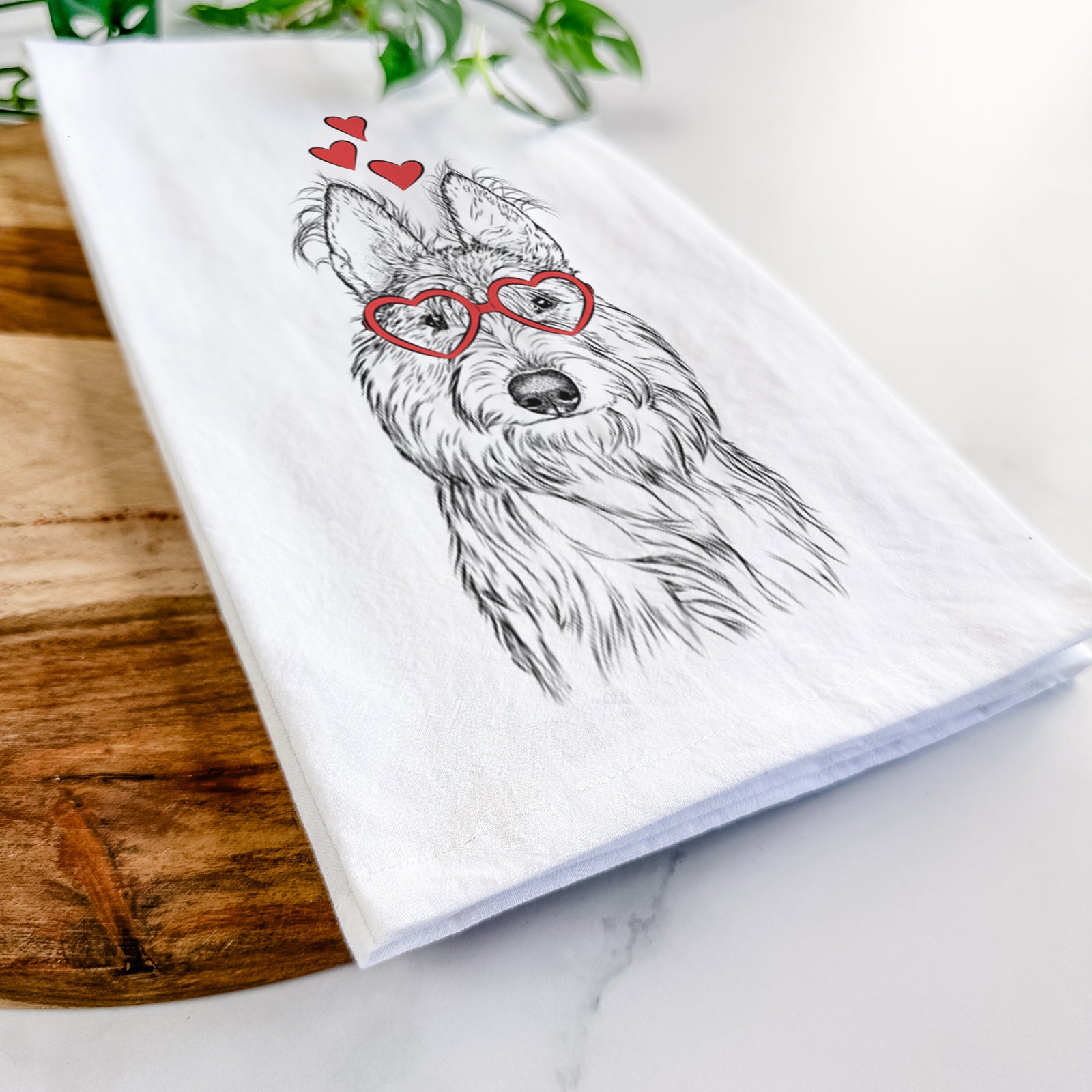Hand-drawn sketch of Luna the Berger Picard wearing heart-shaped glasses on a tea towel