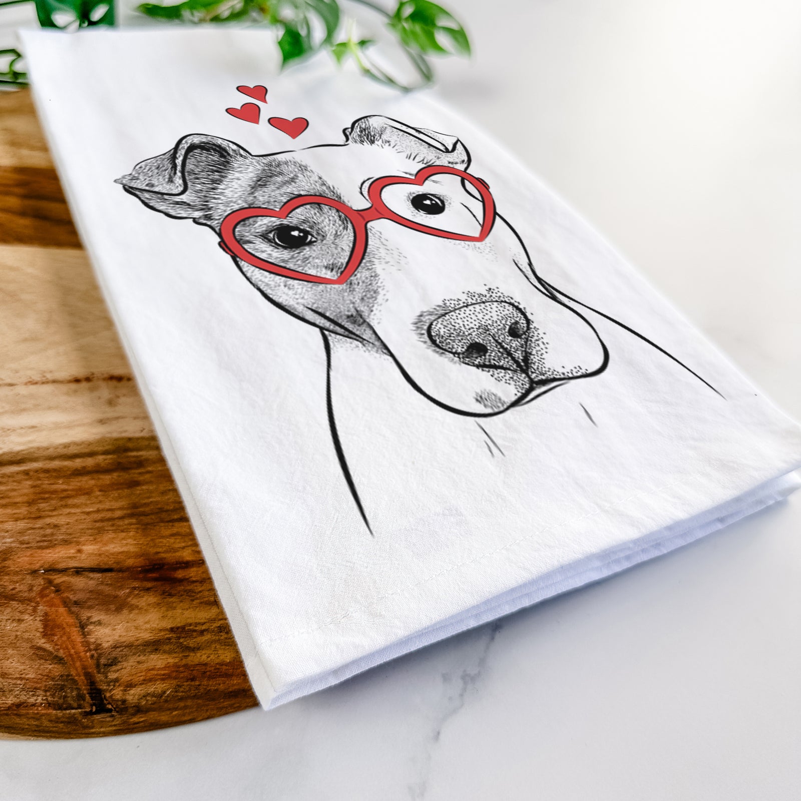 Hand-drawn sketch of Manchi the Pitbull Mix wearing heart-shaped glasses on a tea towel