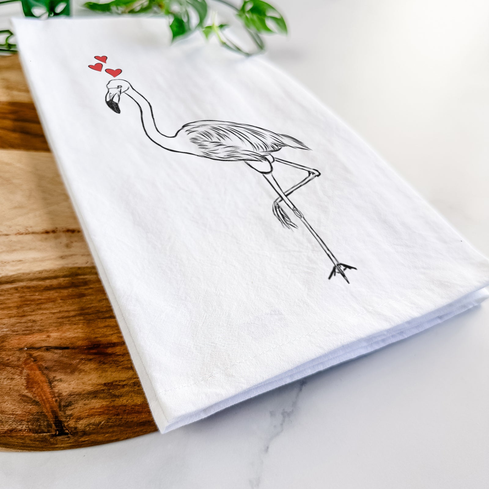 Hand-drawn sketch of Mango the Flamingo wearing heart-shaped glasses on a tea towel