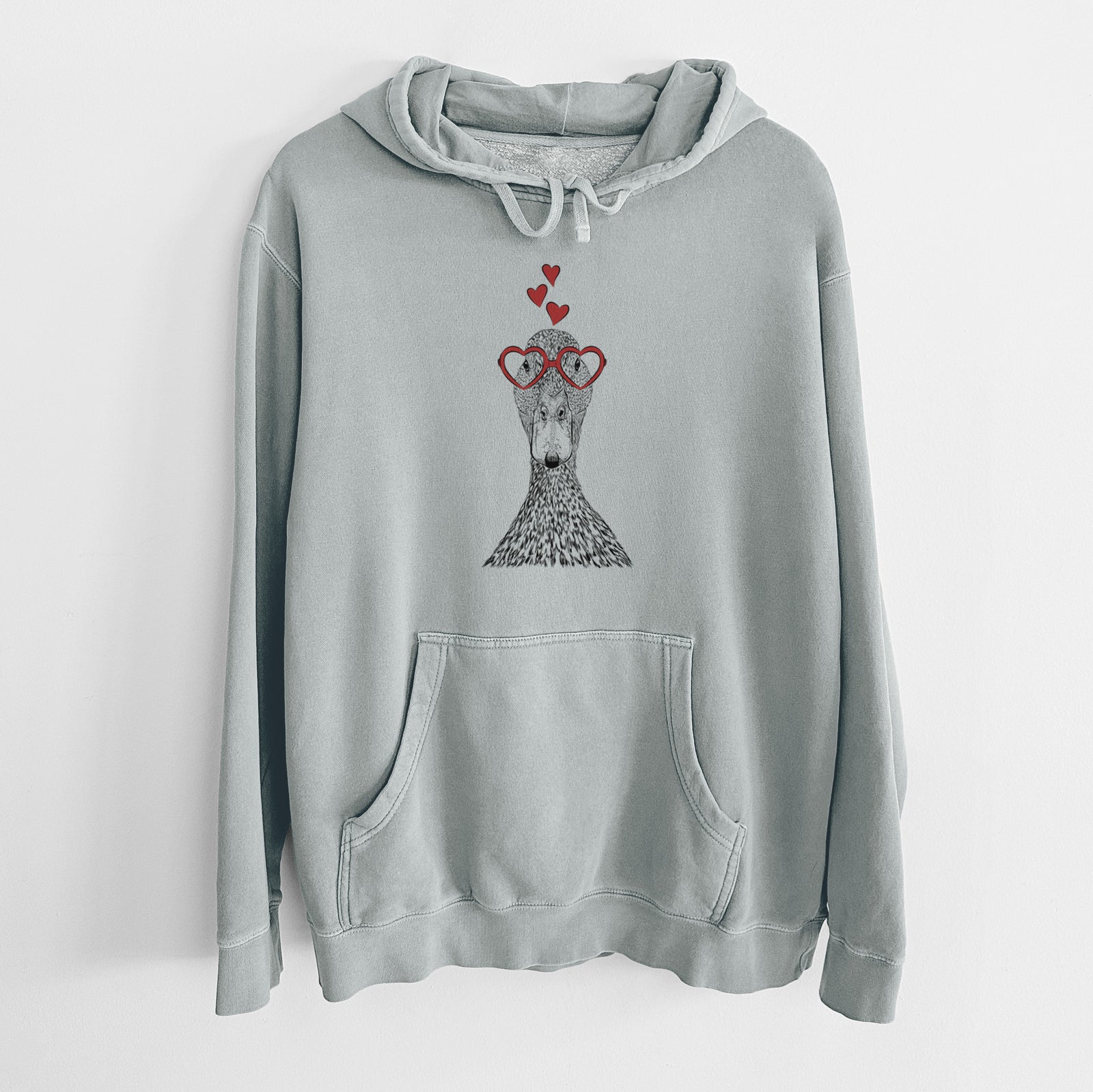 Hand-drawn sketch of Marge the Mallard Duck wearing heart-shaped glasses on a Sage Unisex pigment dyed hoodie