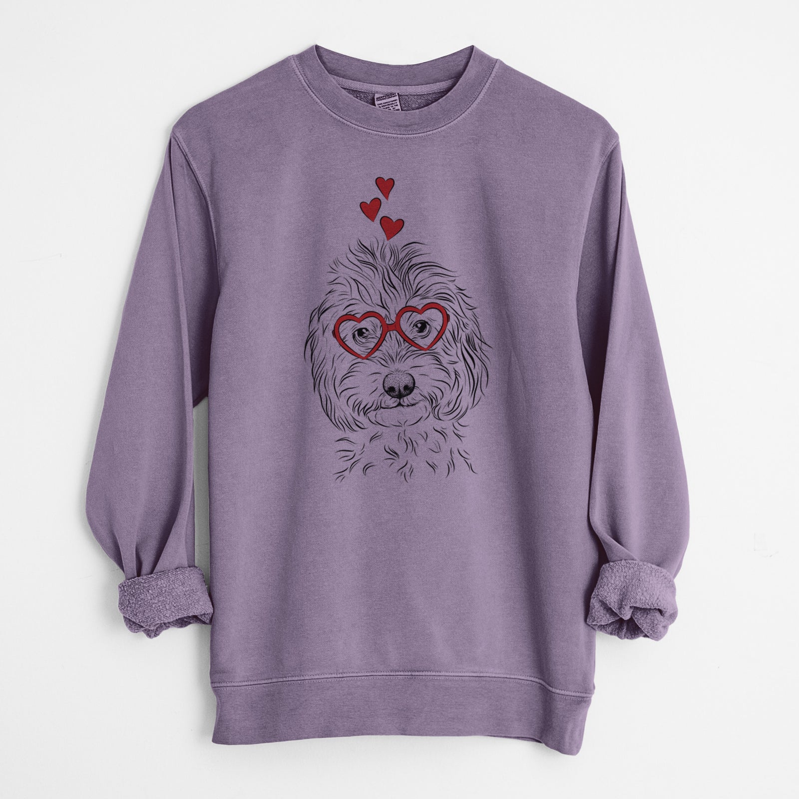 Hand-drawn sketch of Mason the Cavapoo wearing heart-shaped glasses on a Plum Unisex pigment dyed crew sweatshirt