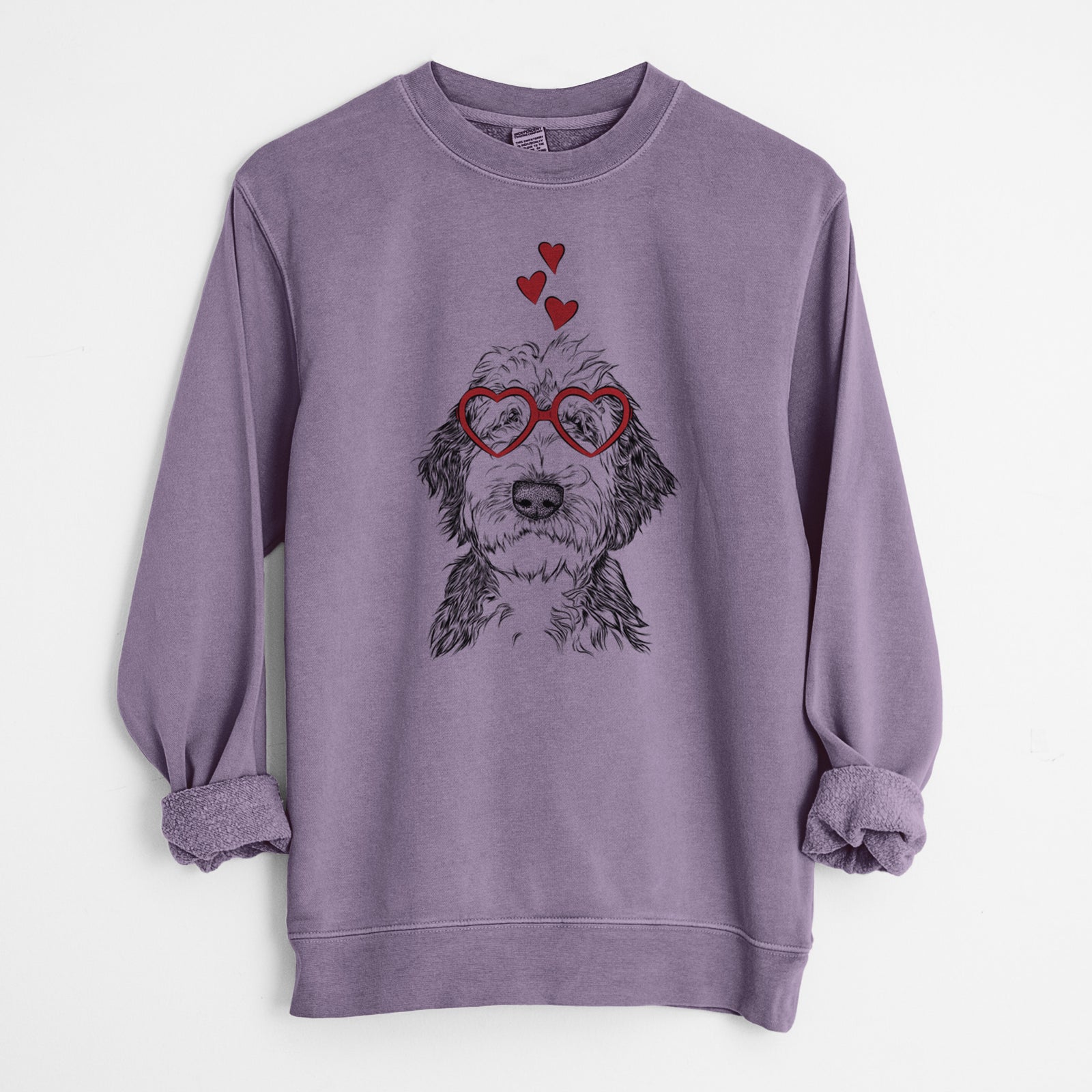 Hand-drawn sketch of Milo Fluff the Sheepadoodle wearing heart-shaped glasses on a Plum Unisex pigment dyed crew sweatshirt