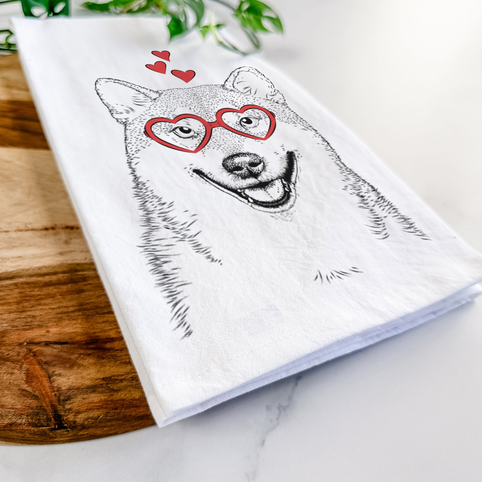 Hand-drawn sketch of Mitsu the Shiba Inu wearing heart-shaped glasses on a tea towel