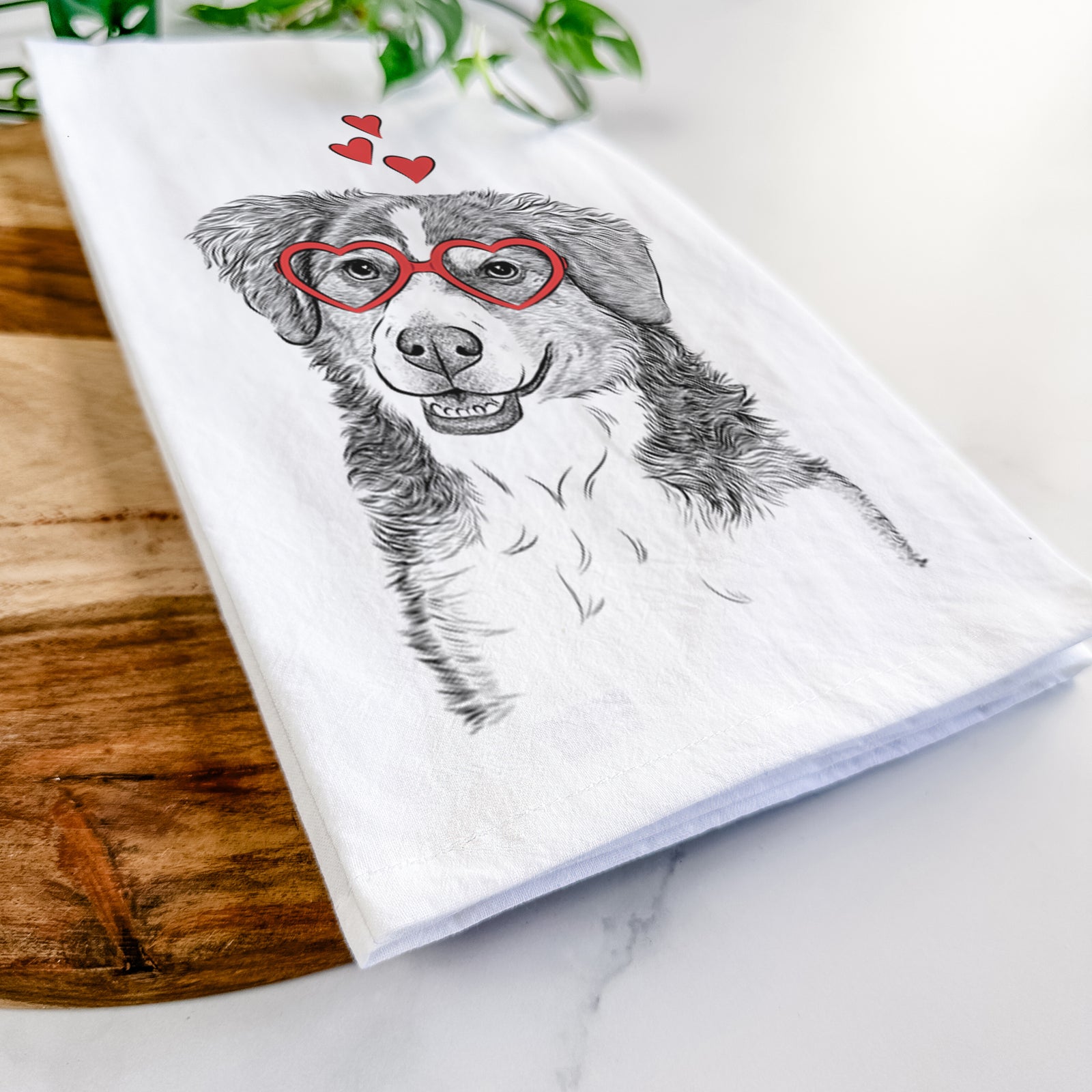 Hand-drawn sketch of Molly the Miniature Bernedoodle wearing heart-shaped glasses on a tea towel