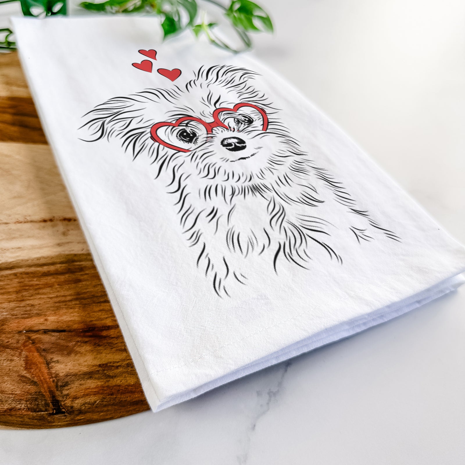Hand-drawn sketch of Mr. Gucci Poochi the Maltese wearing heart-shaped glasses on a tea towel