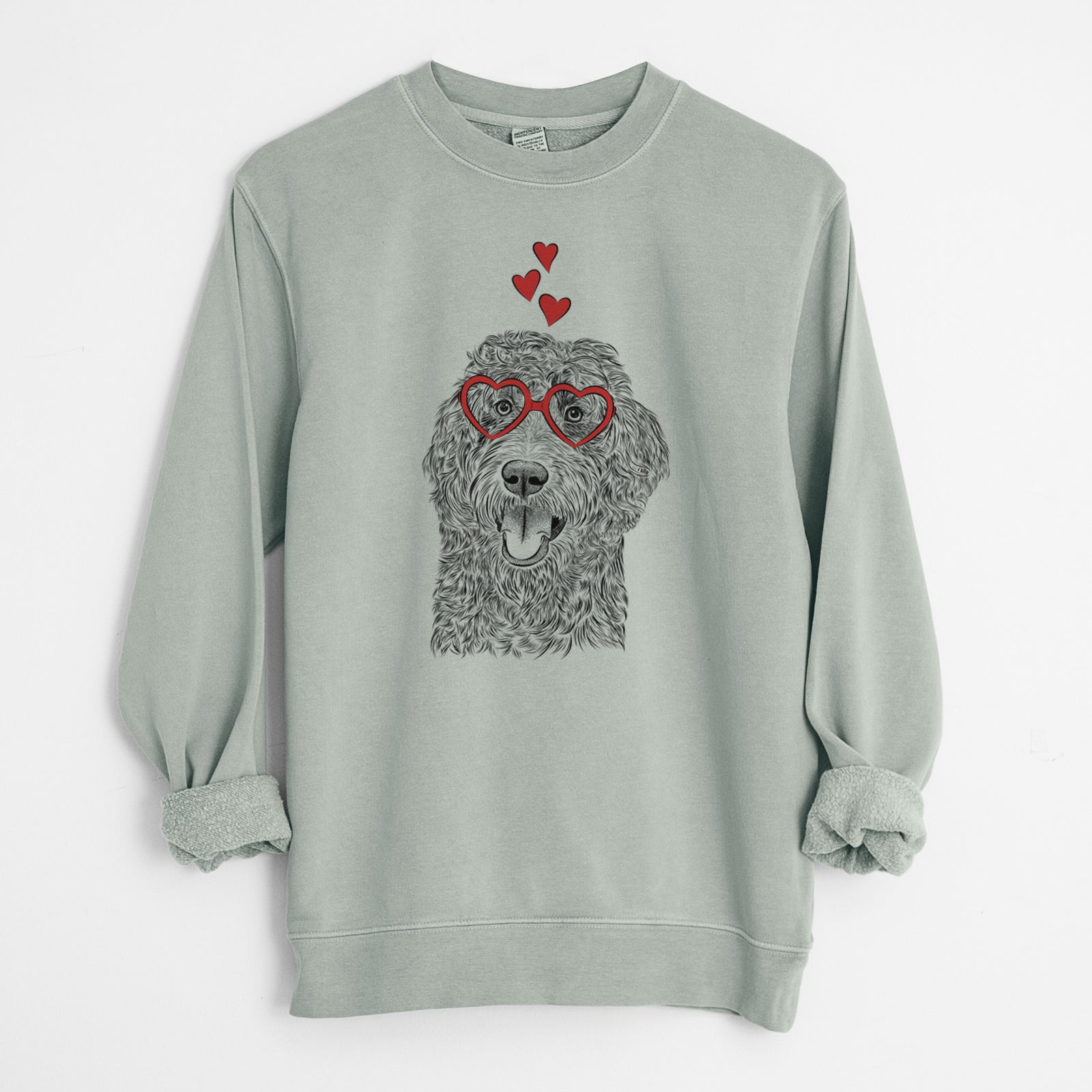 Hand-drawn sketch of Murr Dog the Labradoodle wearing heart-shaped glasses on a Sage Unisex pigment dyed crew sweatshirt