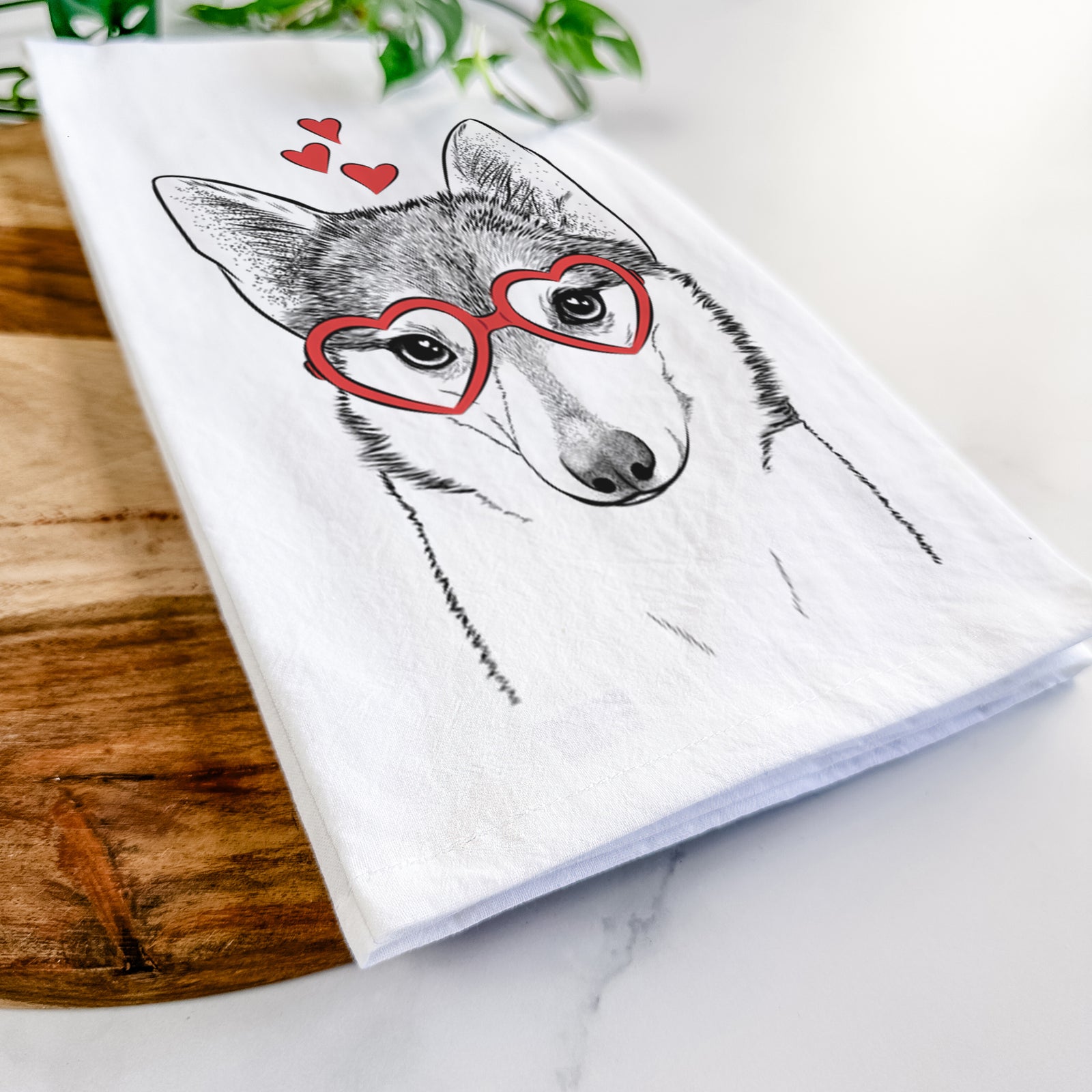 Hand-drawn sketch of Nami the Alaskan Klee Kai wearing heart-shaped glasses on a tea towel