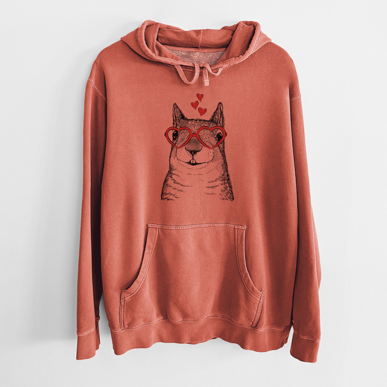 Hand-drawn sketch of Nibbles the Squirrel wearing heart-shaped glasses on an Amber Unisex pigment dyed hoodie