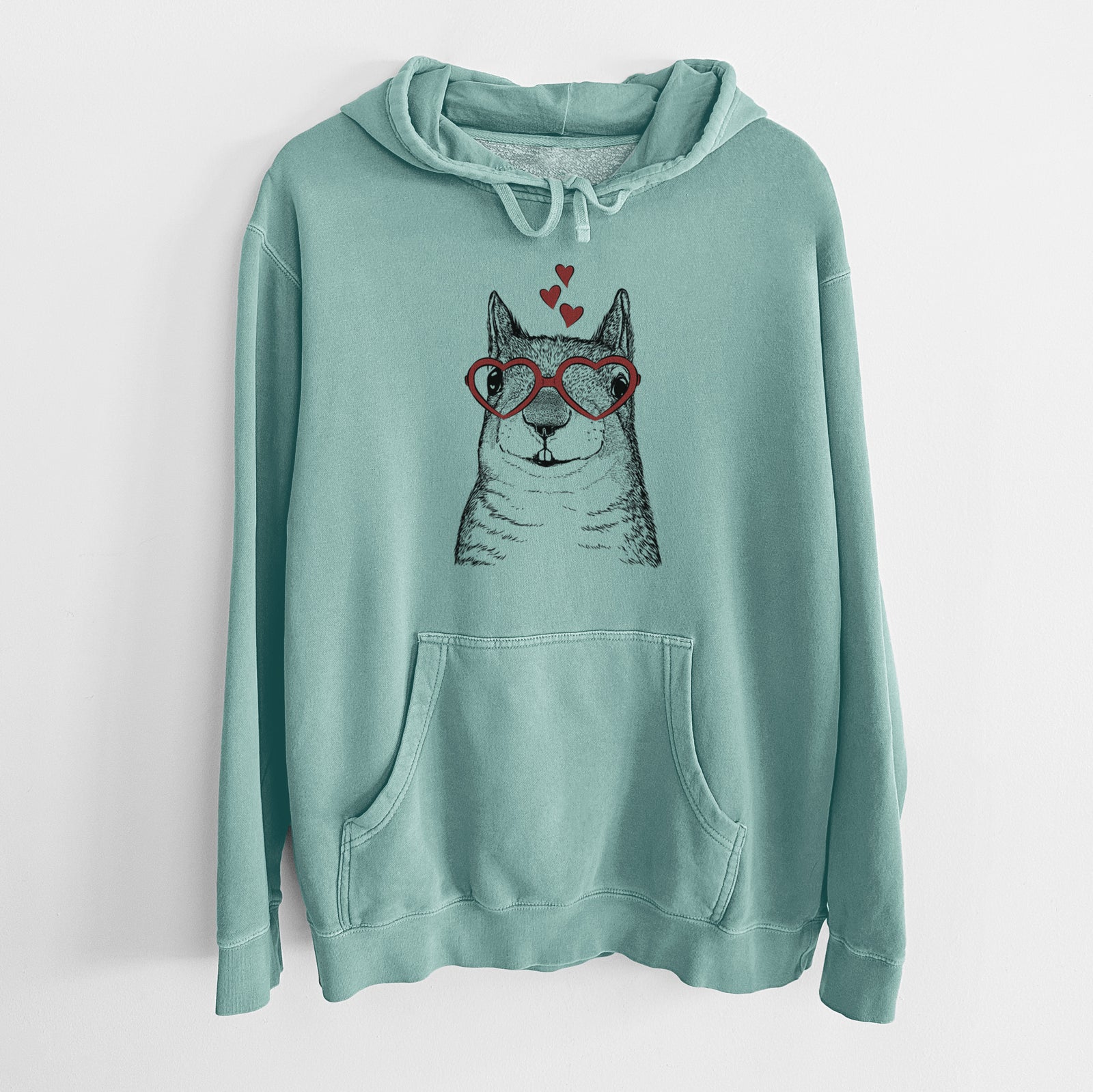 Hand-drawn sketch of Nibbles the Squirrel wearing heart-shaped glasses on a Mint Unisex pigment dyed hoodie