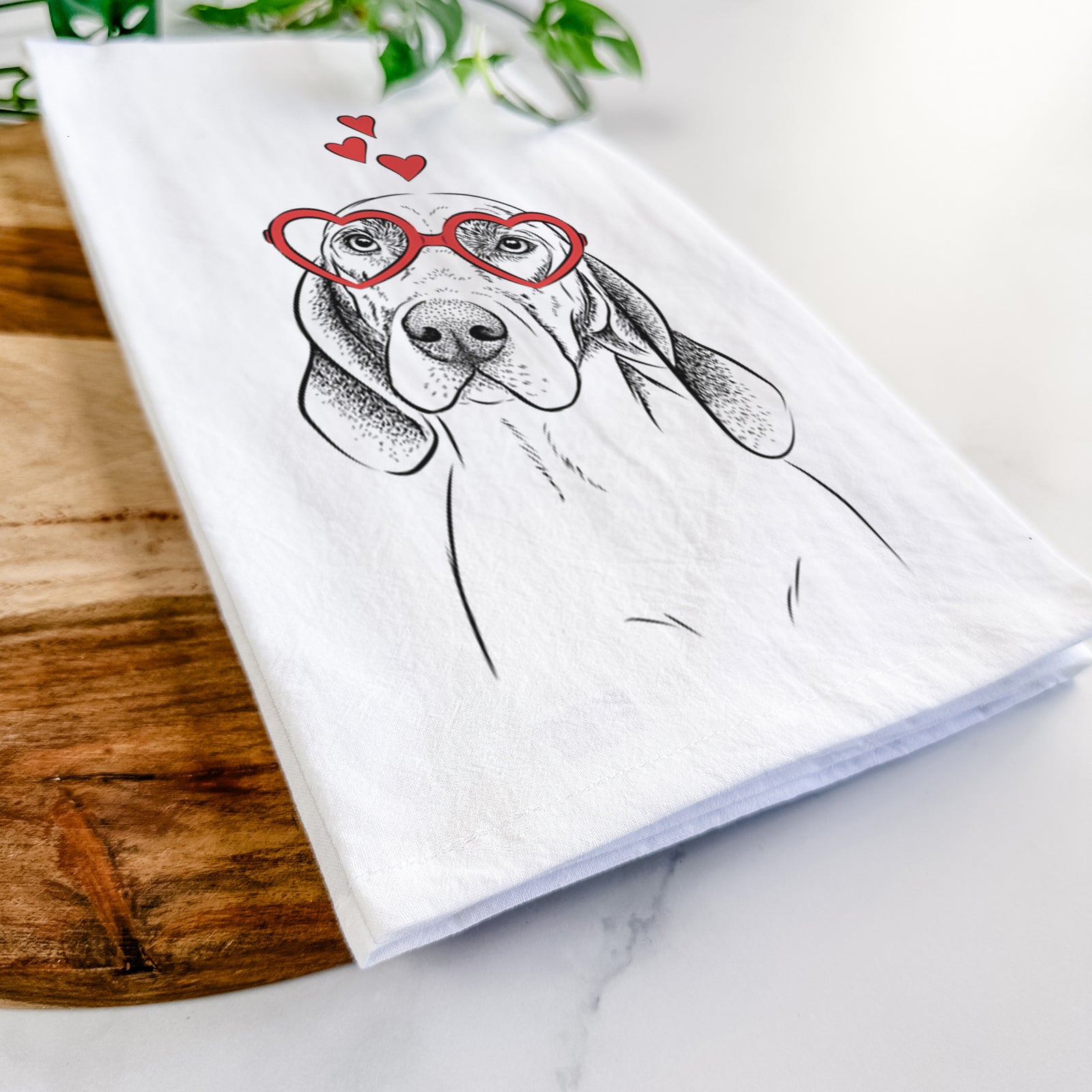 Hand-drawn sketch of Norman the Plott Hound wearing heart-shaped glasses on a tea towel