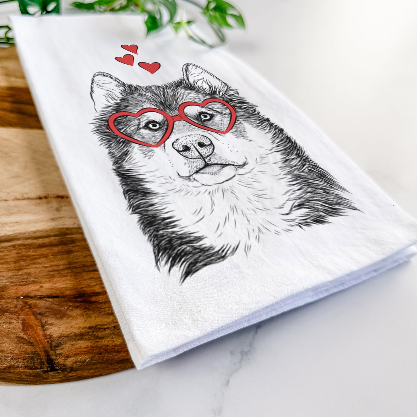 Hand-drawn sketch of Oskar the Canadian Eskimo Dog wearing heart-shaped glasses on a tea towel
