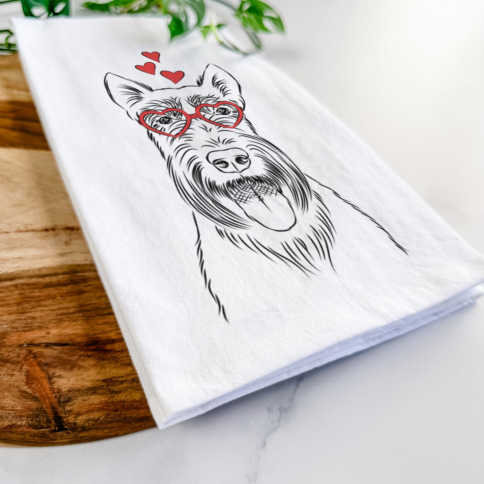 Hand-drawn sketch of Oswald the Scottish Terrier wearing heart-shaped glasses on a tea towel