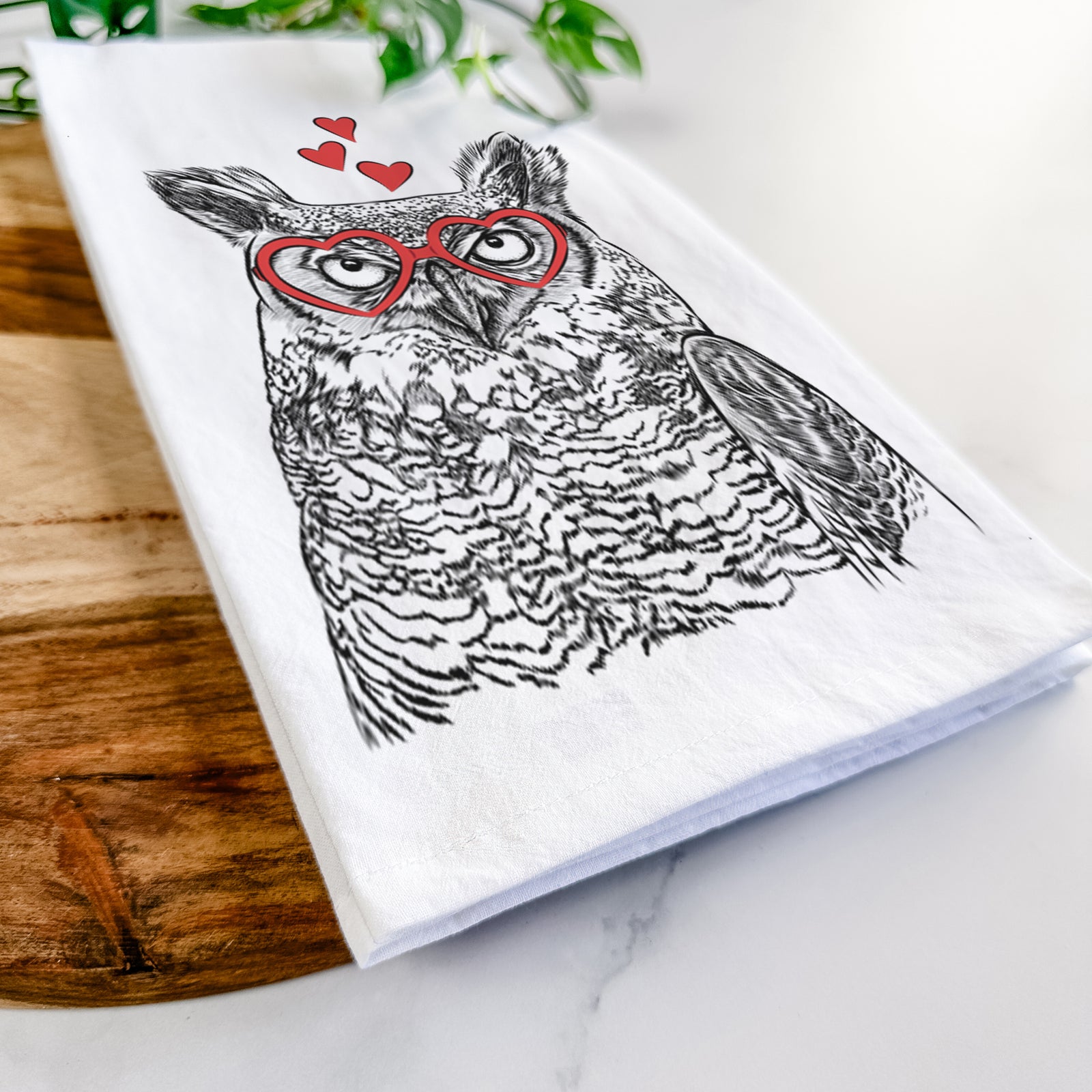 Hand-drawn sketch of Ozwald the Grey Horned Owl wearing heart-shaped glasses on a tea towel