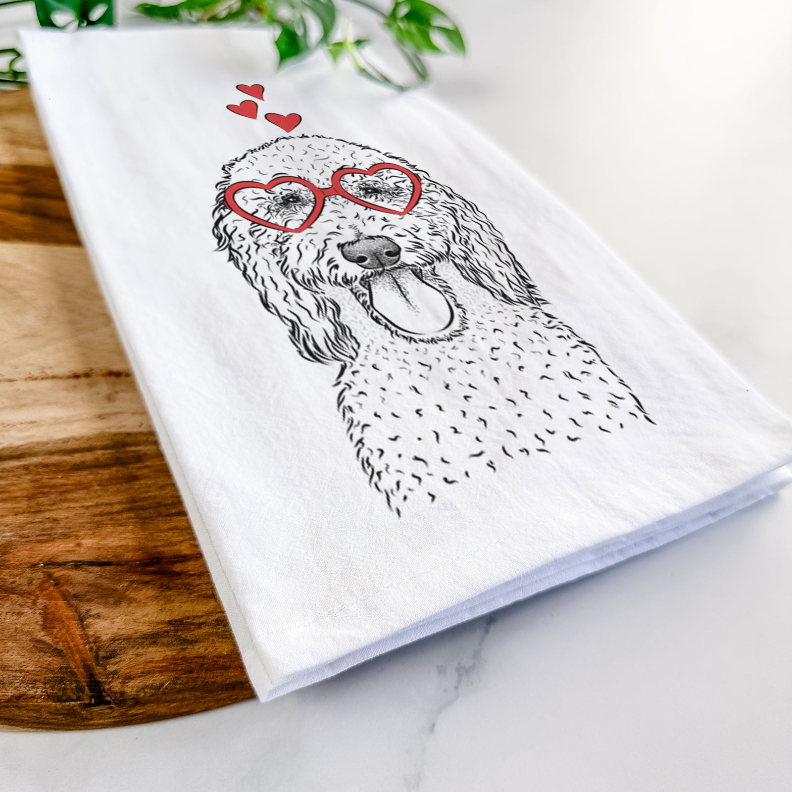 Hand-drawn sketch of Pavlov the Goldendoodle wearing heart-shaped glasses on a tea towel