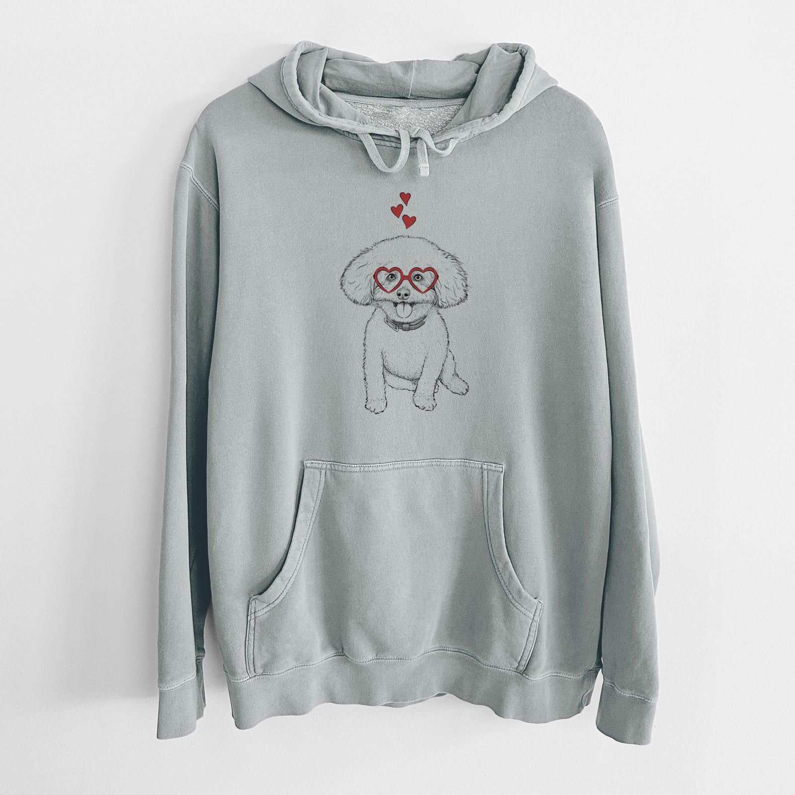 Hand-drawn sketch of Peyton the Bichon Frise wearing heart-shaped glasses on a Sage Unisex pigment dyed hoodie
