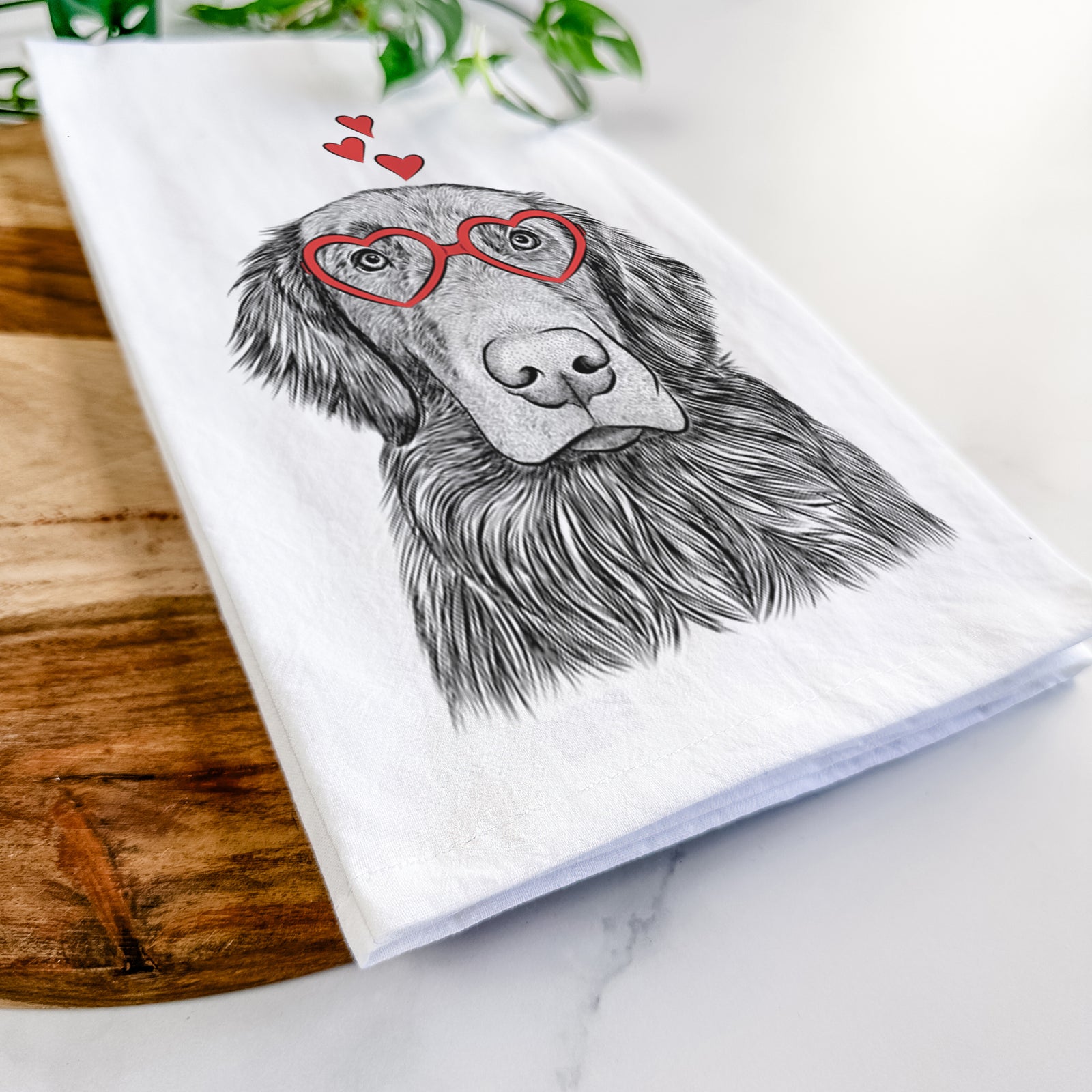 Hand-drawn sketch of Pippin the Flat Coated Retriever wearing heart-shaped glasses on a tea towel
