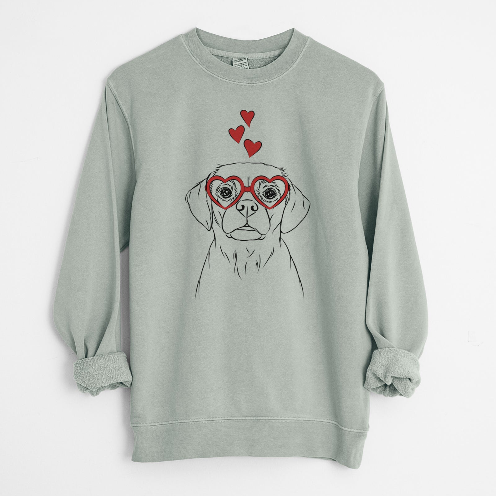 Hand-drawn sketch of Popcorn the Puggle wearing heart-shaped glasses on a Sage Unisex pigment dyed crew sweatshirt