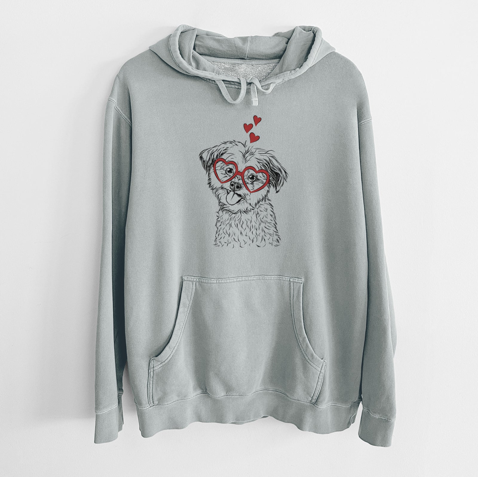 Hand-drawn sketch of Puff the Malshi wearing heart-shaped glasses on a Sage Unisex pigment dyed hoodie