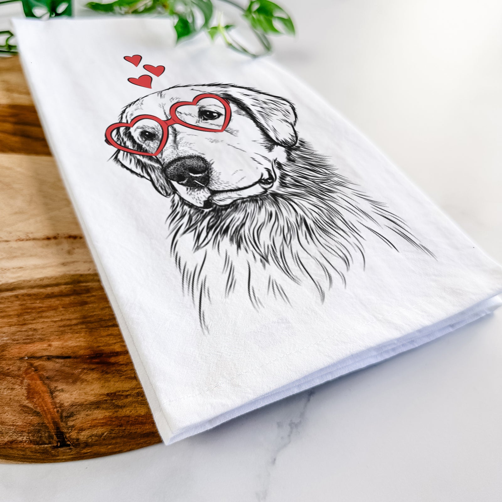 Hand-drawn sketch of Quinn the Golden Retriever wearing heart-shaped glasses on a tea towel