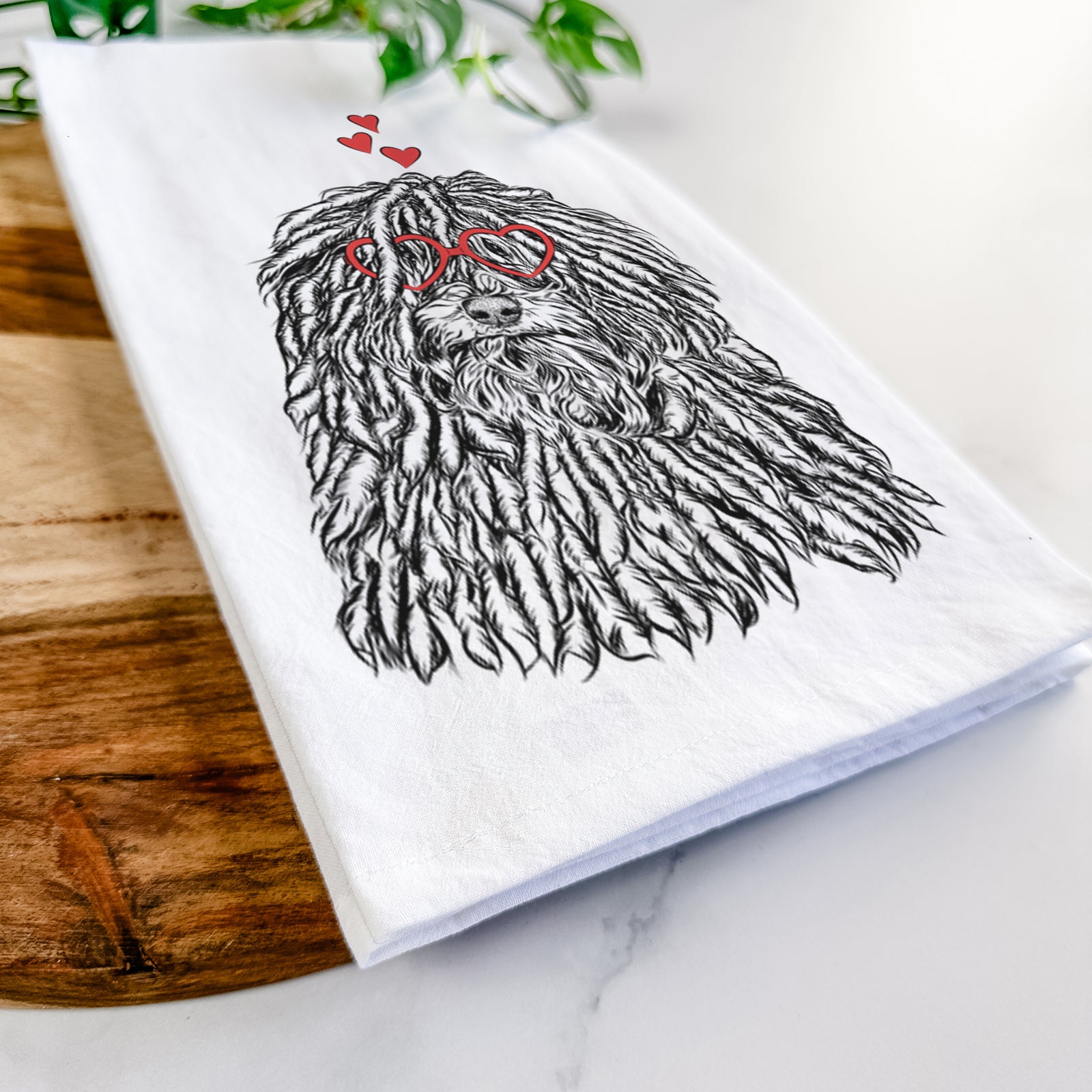 Hand-drawn sketch of Rezi the Puli wearing heart-shaped glasses on a tea towel