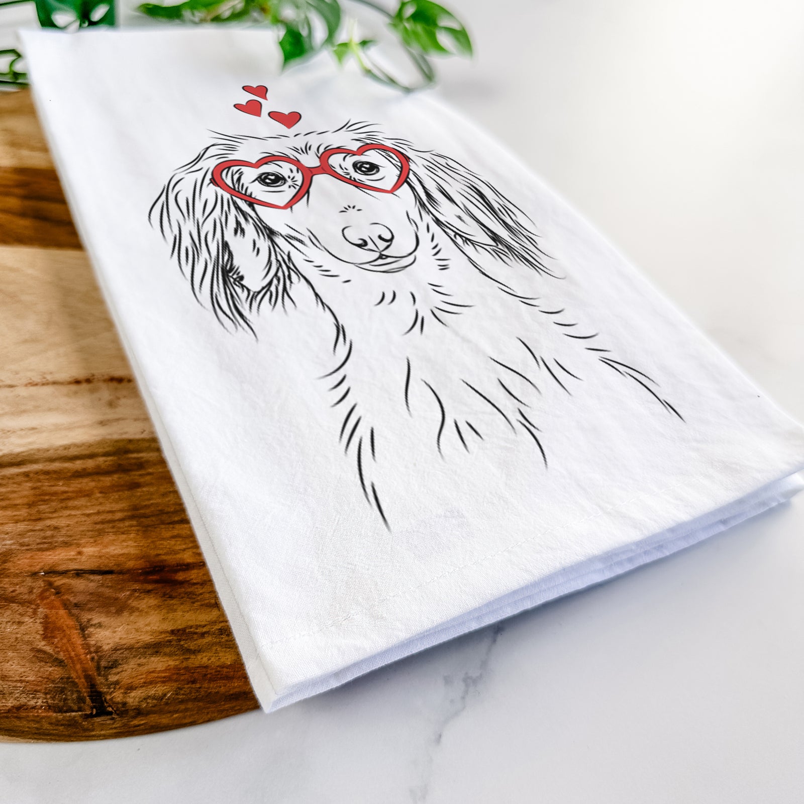 Hand-drawn sketch of Roux the Long Haired Dachshund wearing heart-shaped glasses on a tea towel