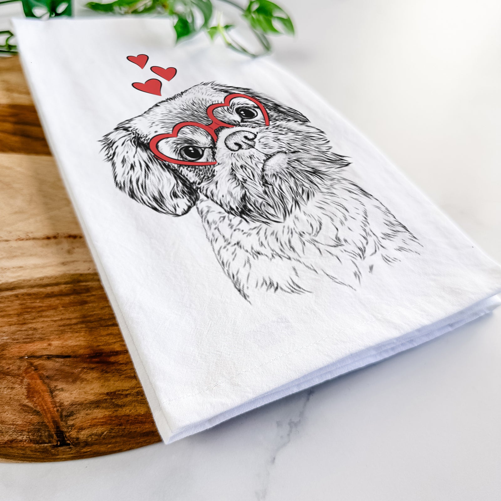 Hand-drawn sketch of Rufus the Shiffon wearing heart-shaped glasses on a tea towel