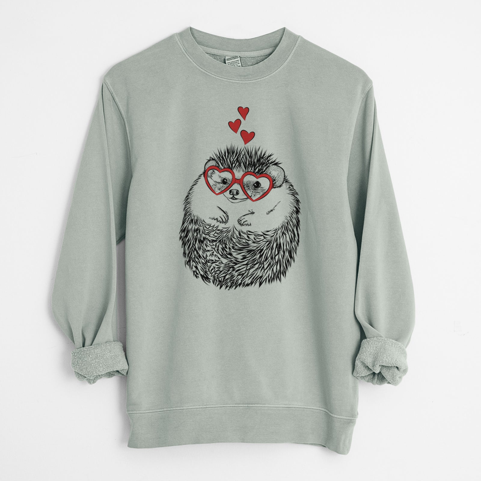 Hand-drawn sketch of Sid the Hedgehog wearing heart-shaped glasses on a Sage Unisex pigment dyed crew sweatshirt