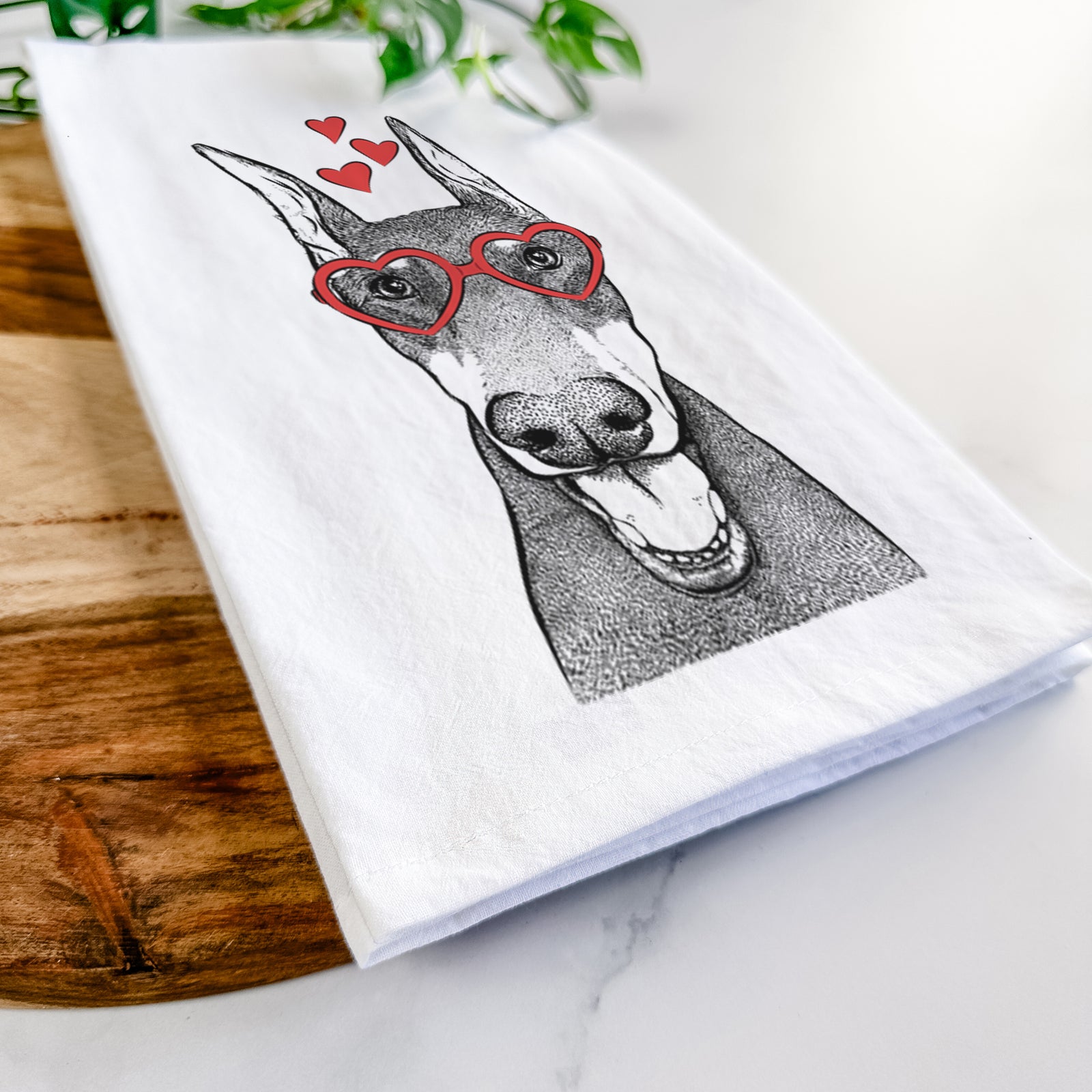 Hand-drawn sketch of Sir Duke the Doberman Pinscher wearing heart-shaped glasses on a tea towel