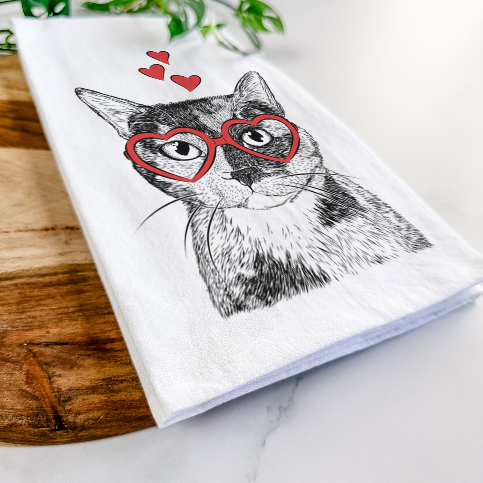 Hand-drawn sketch of Spooky Kitty the Tortoiseshell Cat wearing heart-shaped glasses on a tea towel