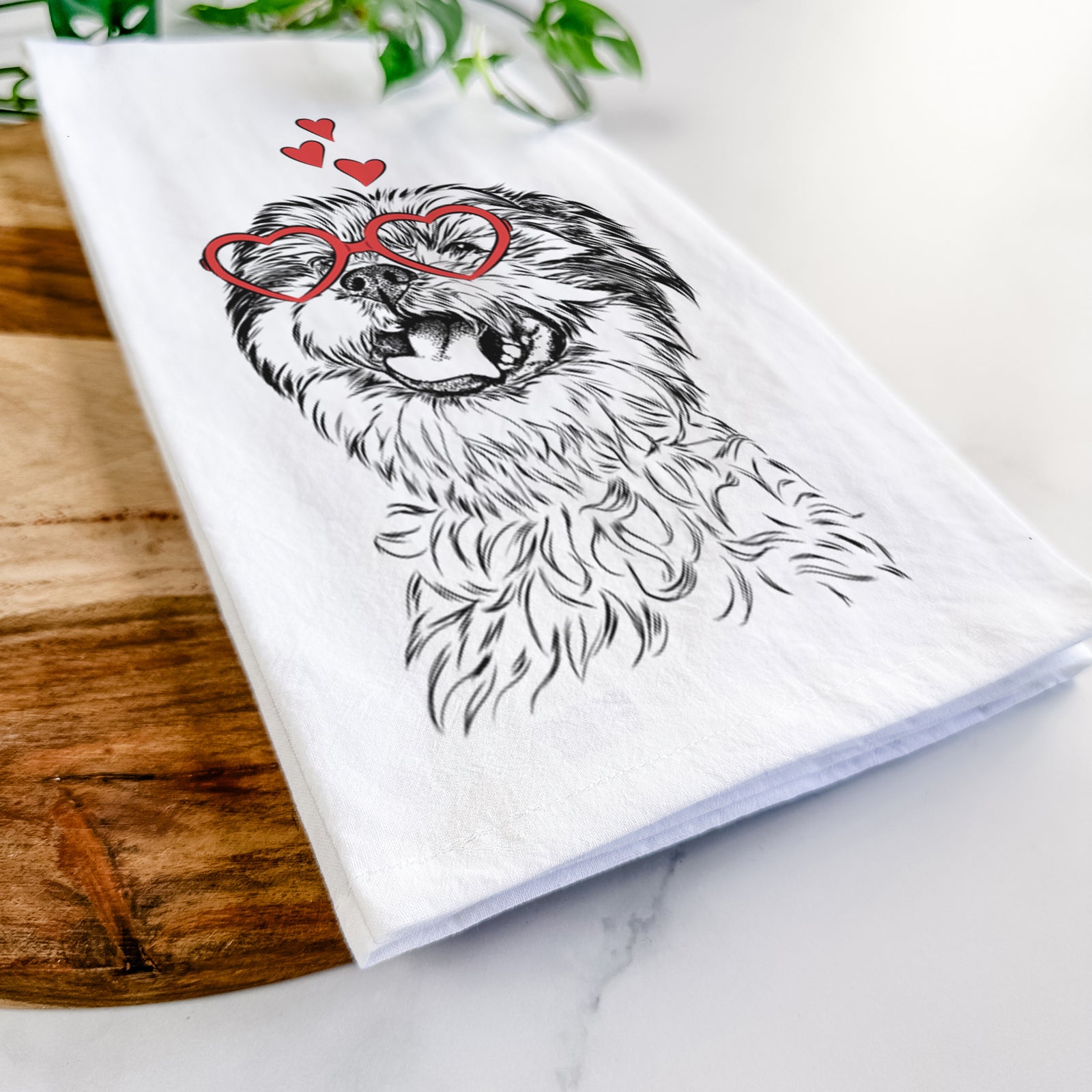Hand-drawn sketch of Sugar the Malshi wearing heart-shaped glasses on a tea towel