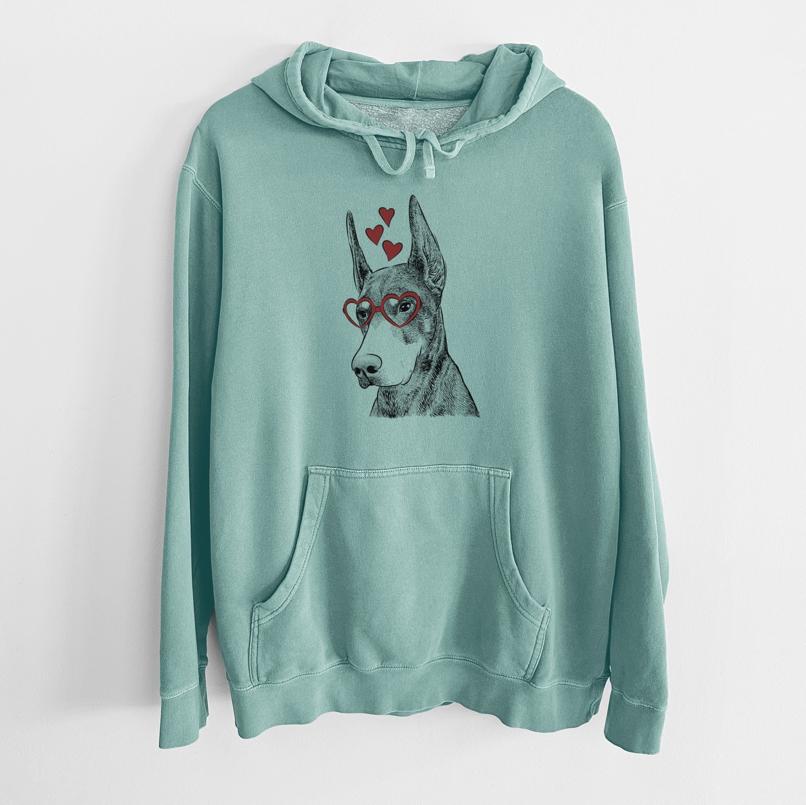 Hand-drawn sketch of Sunny the Doberman Pinscher wearing heart-shaped glasses on a Mint Unisex pigment dyed hoodie