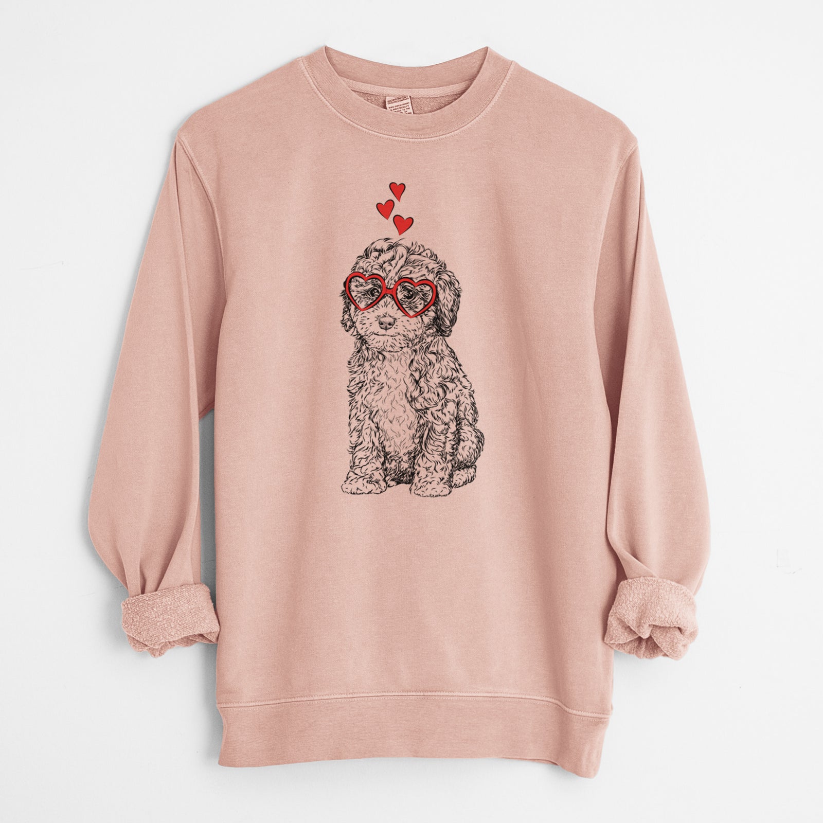Hand-drawn sketch of Sweet Tea the Mini Doodle wearing heart-shaped glasses on a Dusty Pink Unisex pigment dyed crew sweatshirt