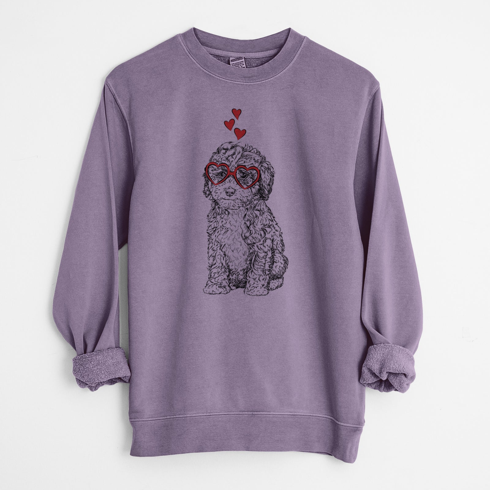 Hand-drawn sketch of Sweet Tea the Mini Doodle wearing heart-shaped glasses on a Plum Unisex pigment dyed crew sweatshirt