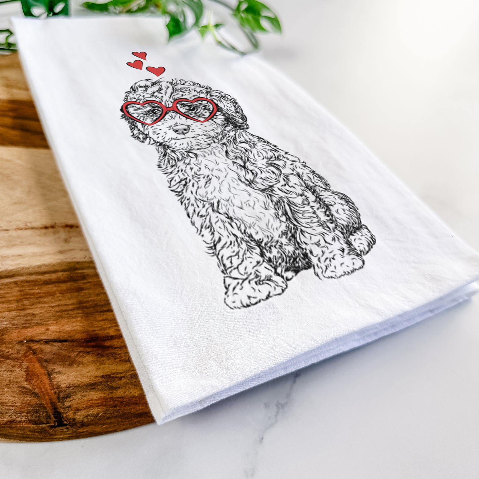 Hand-drawn sketch of Sweet Tea the Mini Doodle wearing heart-shaped glasses on a tea towel