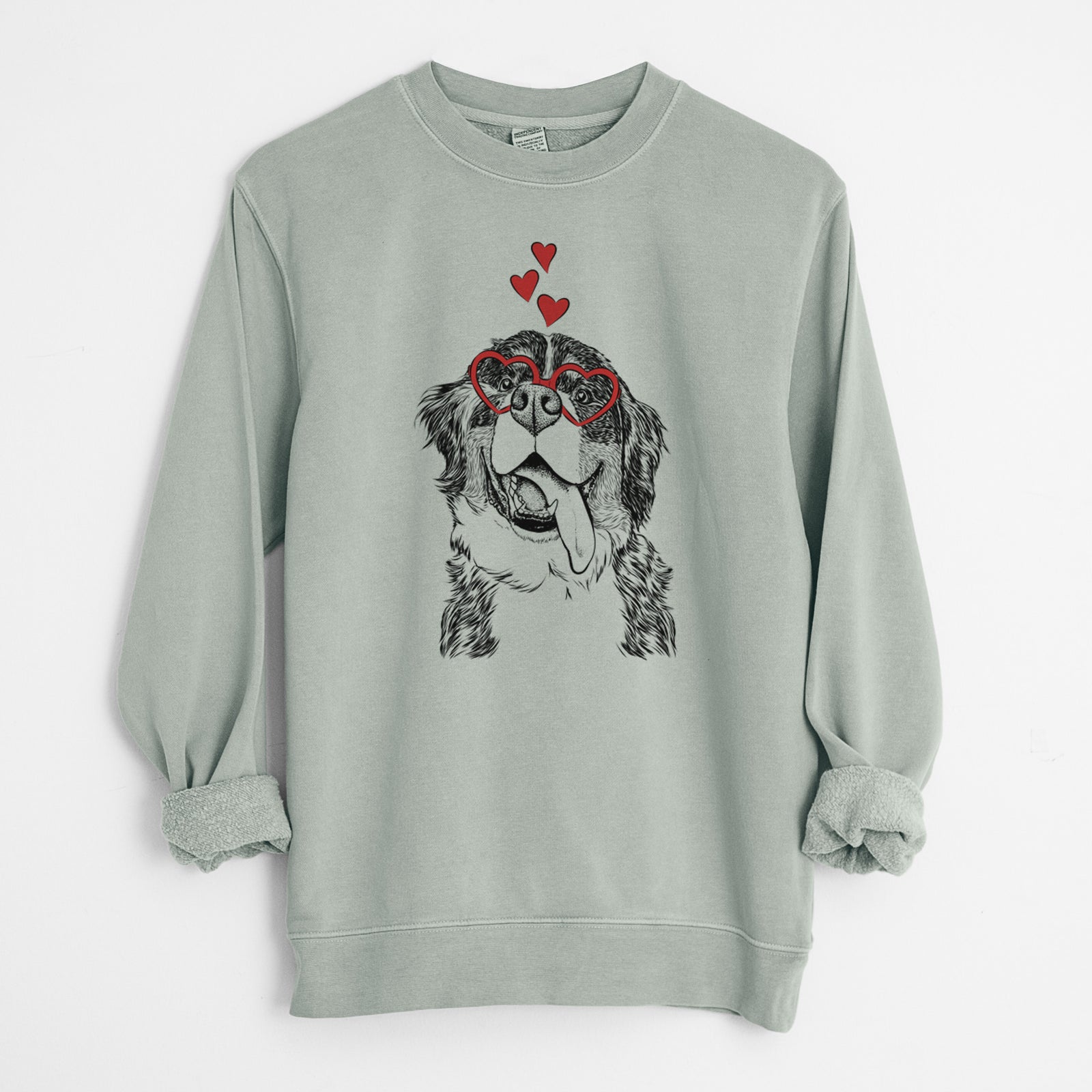 Hand-drawn sketch of Theo the Bernese Mountain Dog wearing heart-shaped glasses on a Sage Unisex pigment dyed crew sweatshirt